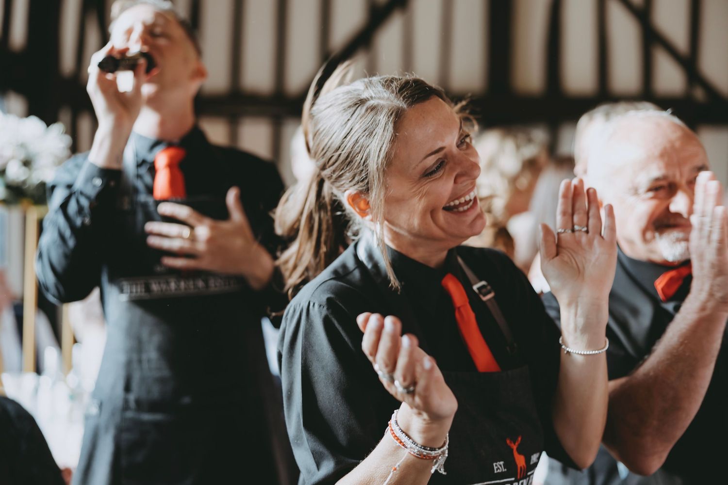 Candid moments of wedding guests laughing and celebrating at an indoor reception.