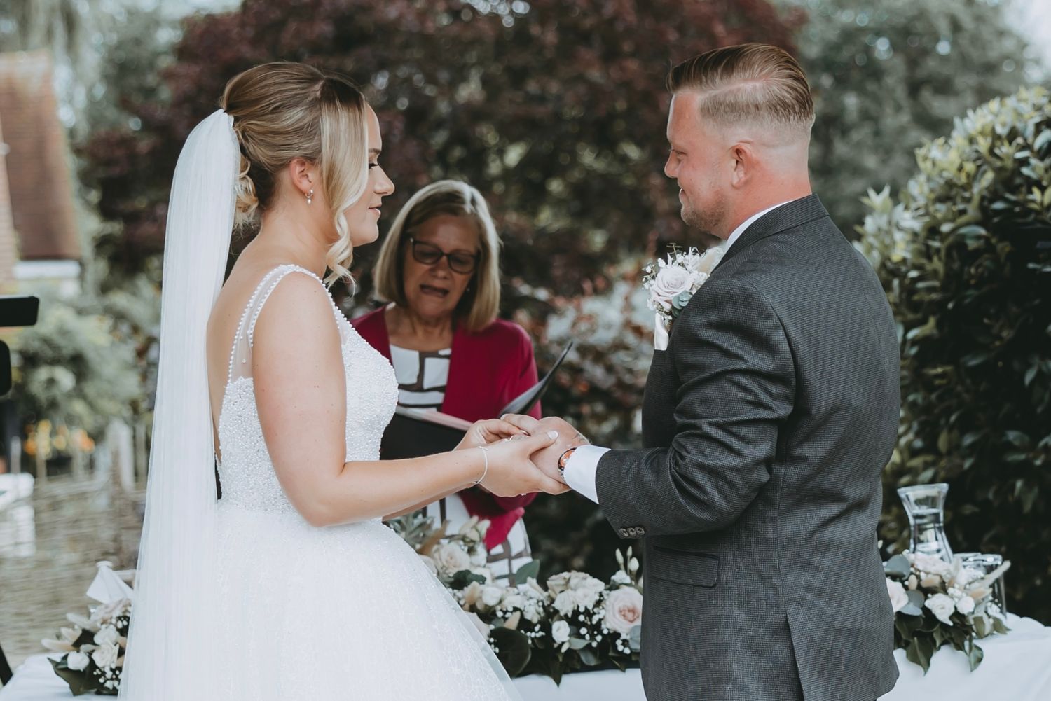 An intimate wedding ceremony moment with an officiant in red conducting the service.