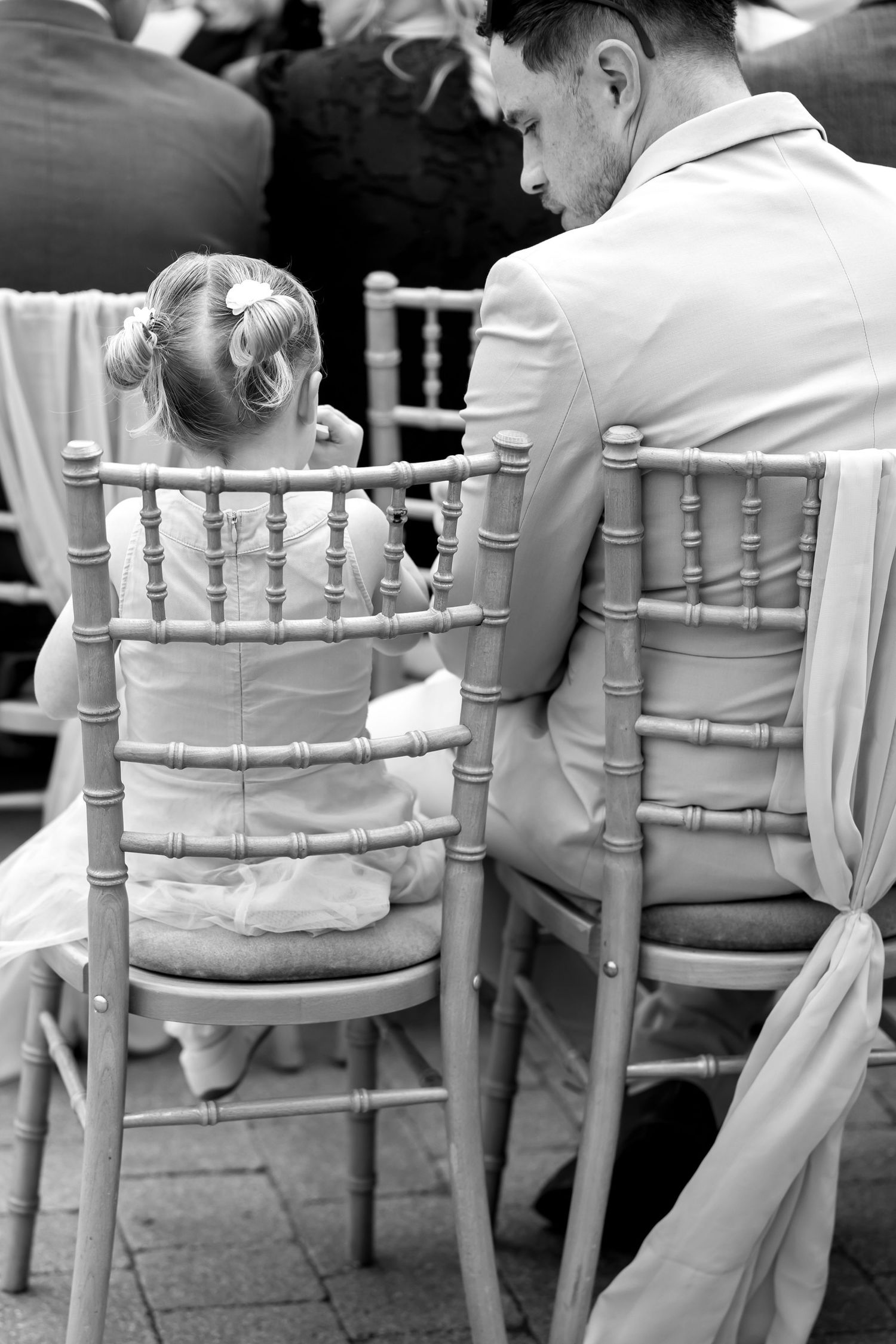 Row of white chiavari chairs arranged at an outdoor venue.