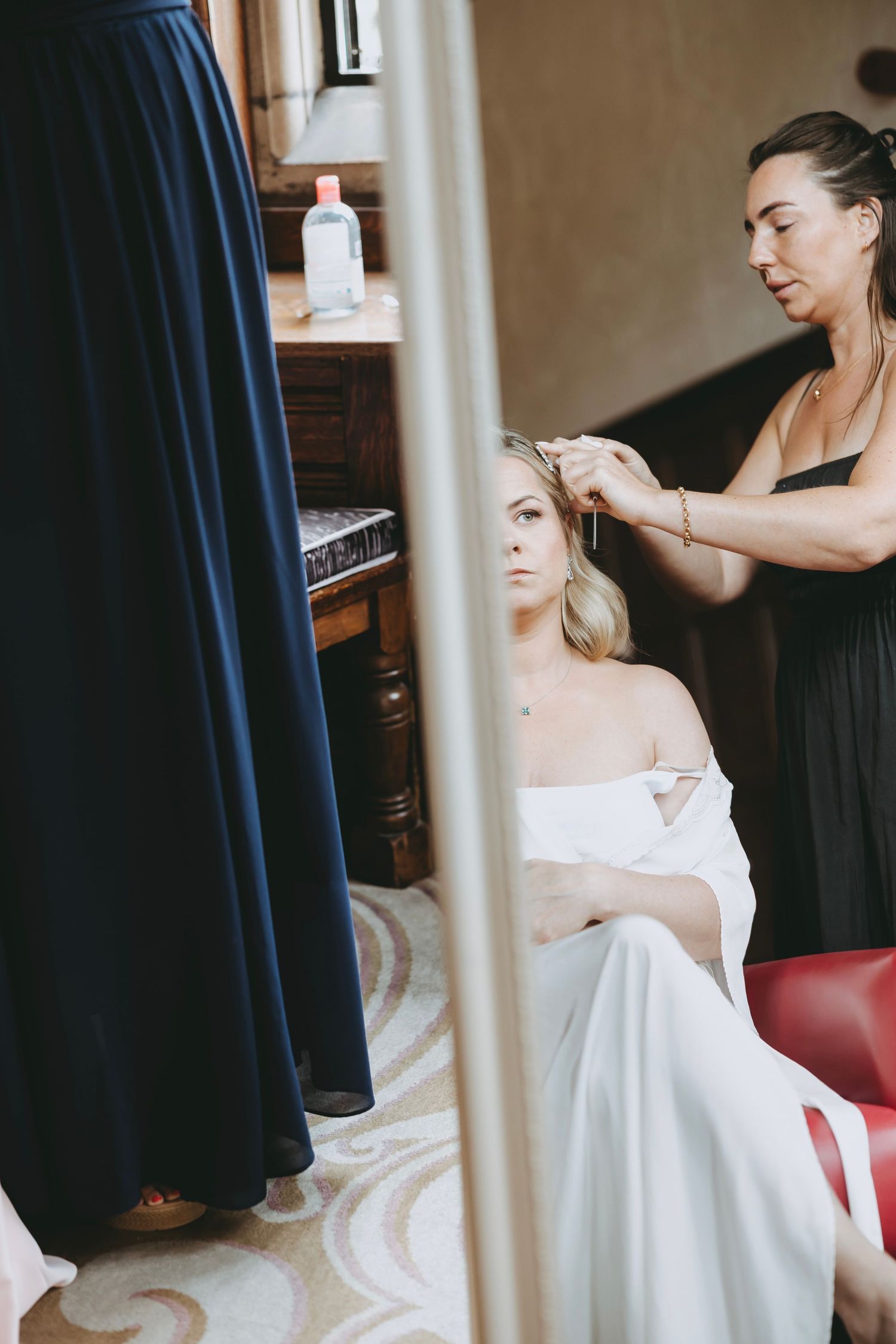 Wedding preparation scene with navy and white dresses in an elegant room.
