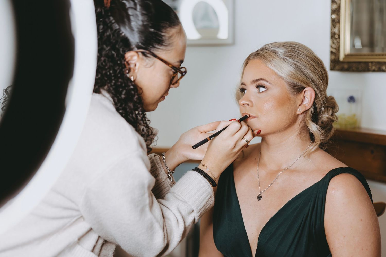 Wedding day makeup application in natural window light.