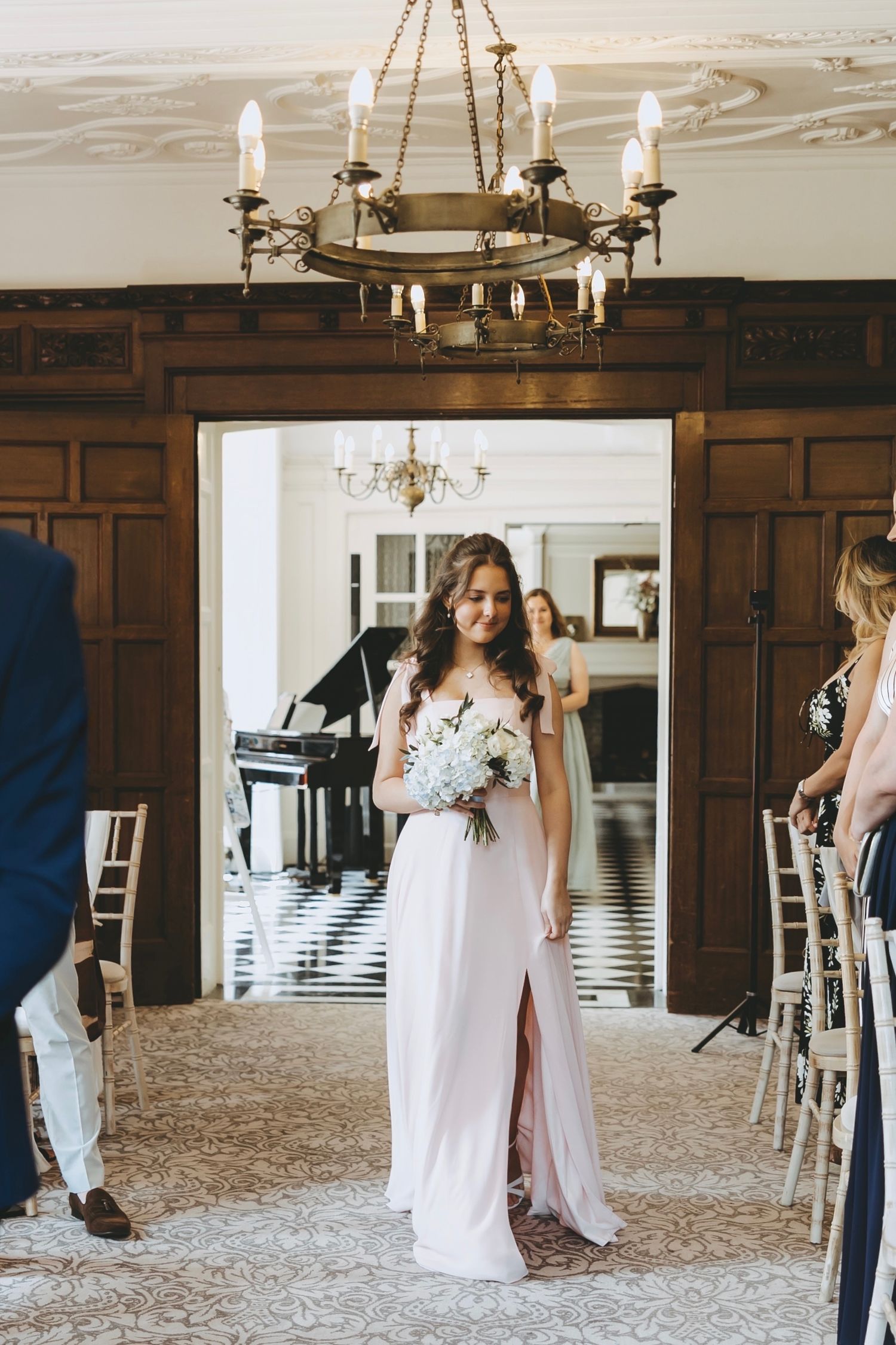 Wedding ceremony space with elegant chandelier and classic wood-paneled walls.