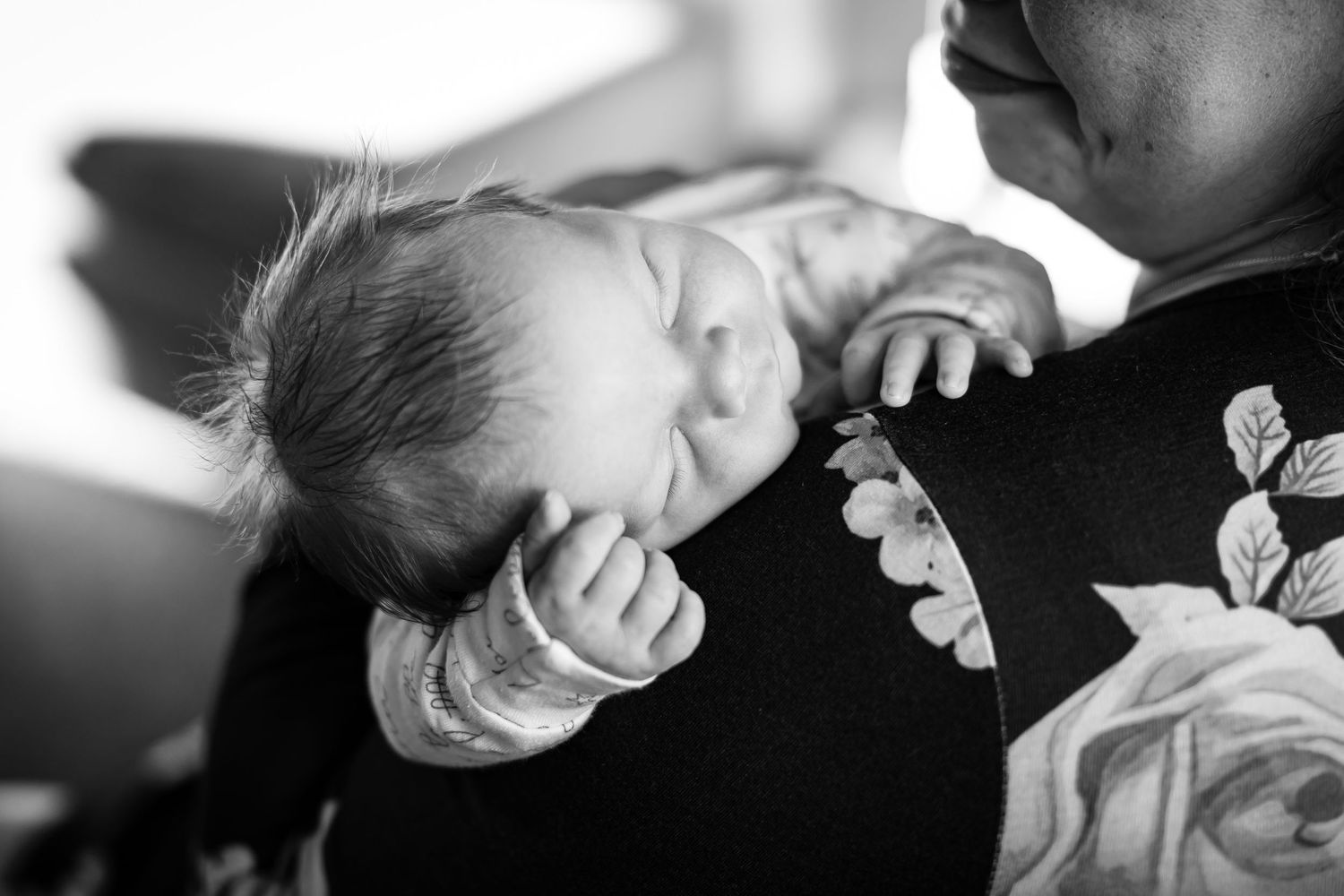 A collection of black and white photos showing tender moments between a parent and baby arranged in a collage.