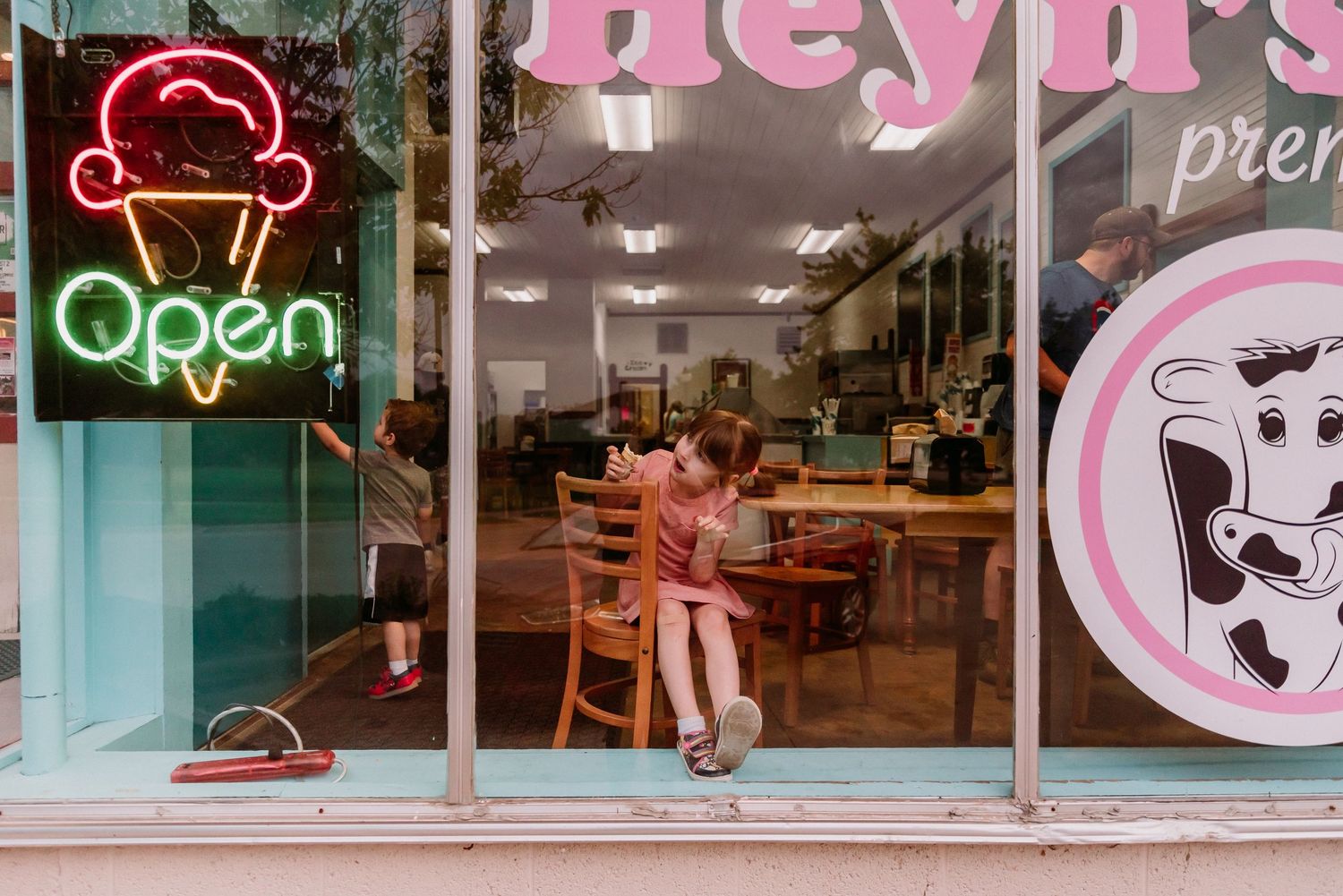 Pink neon signs illuminate storefront windows with retro style design.