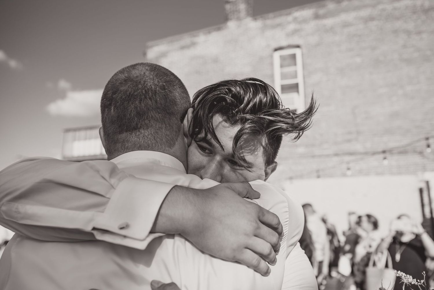 Candid wedding moments captured in a series of black and white photographs outdoors.