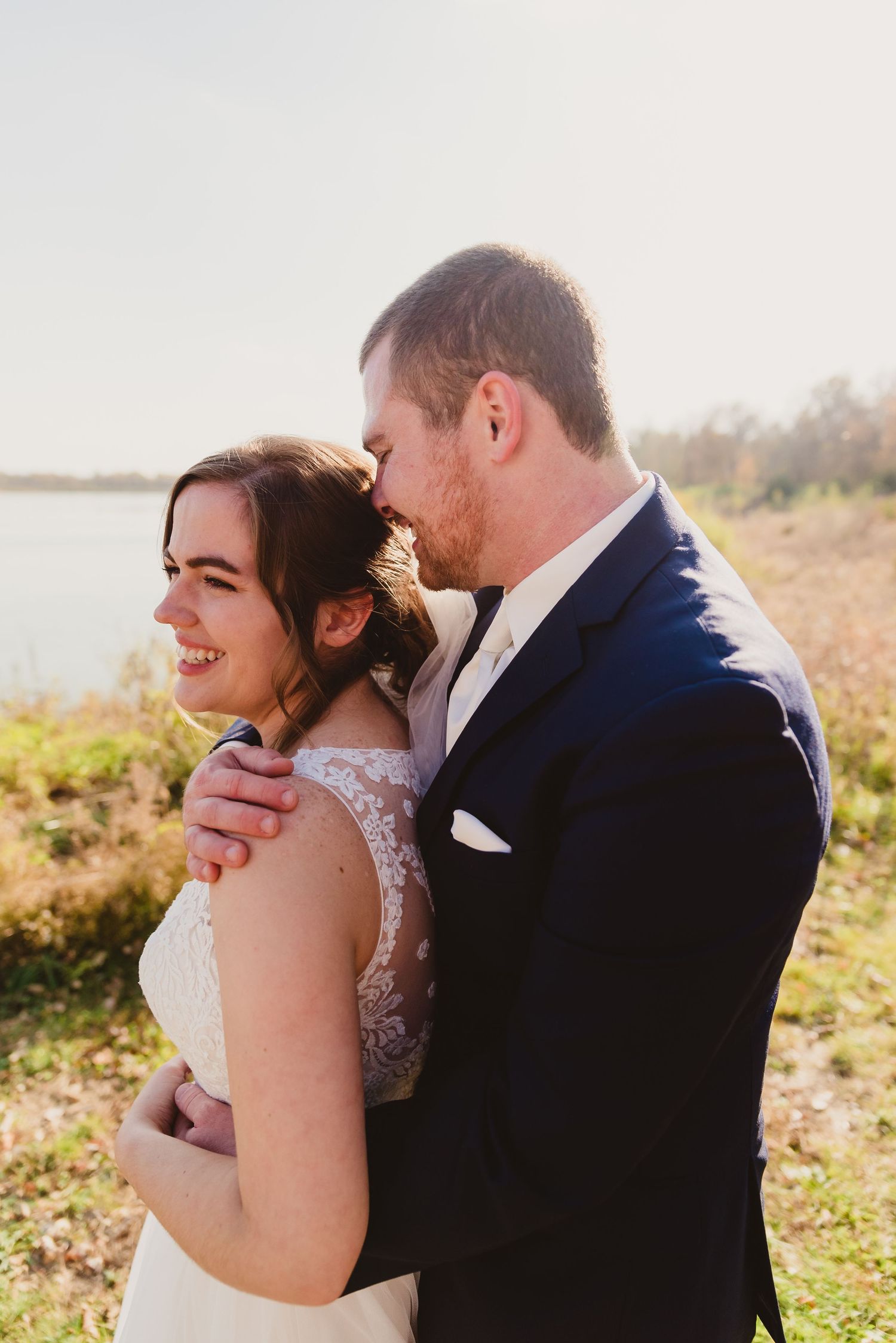 Intimate outdoor portrait session in golden sunlight with natural landscape backdrop.