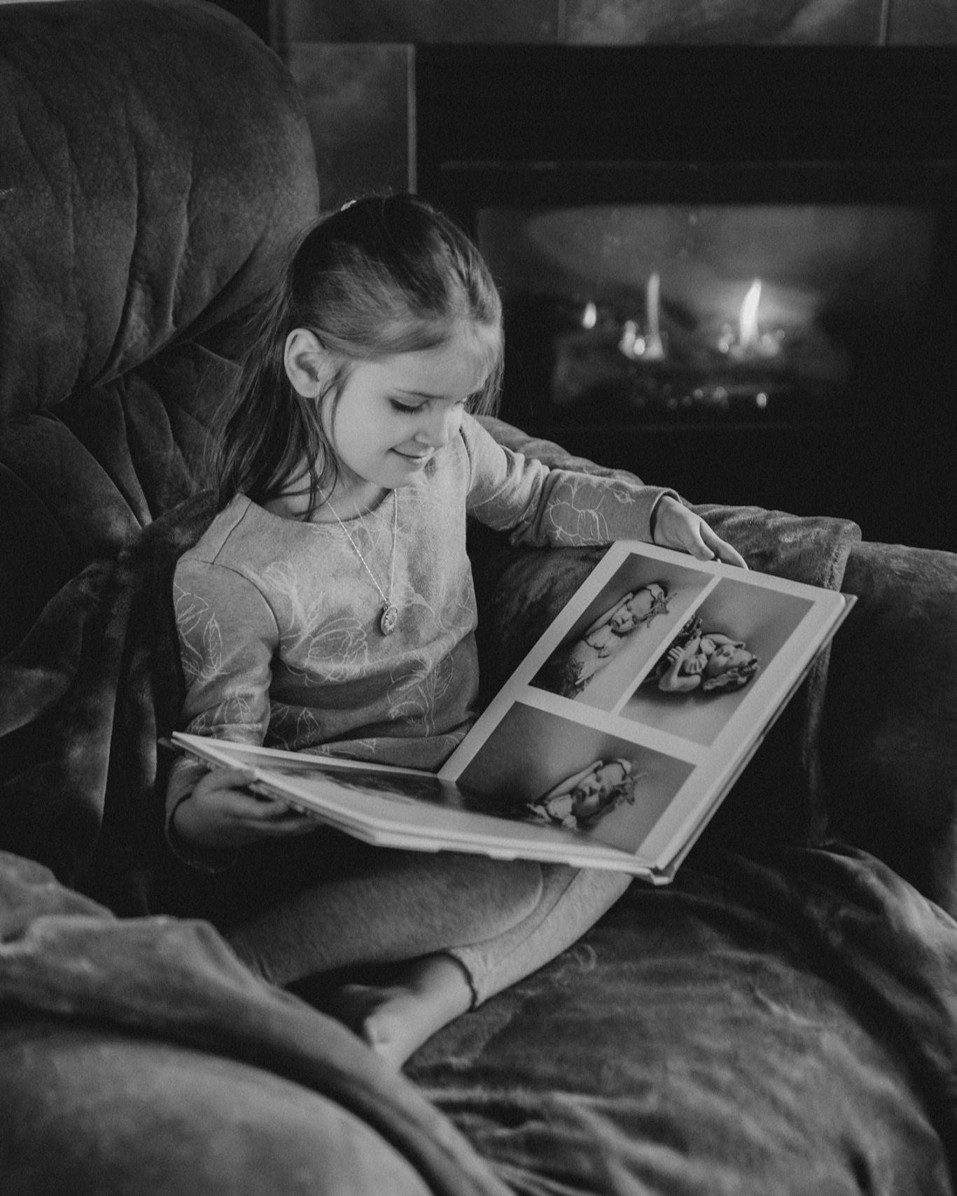 Black and white photos show a child reading a picture book in bed.