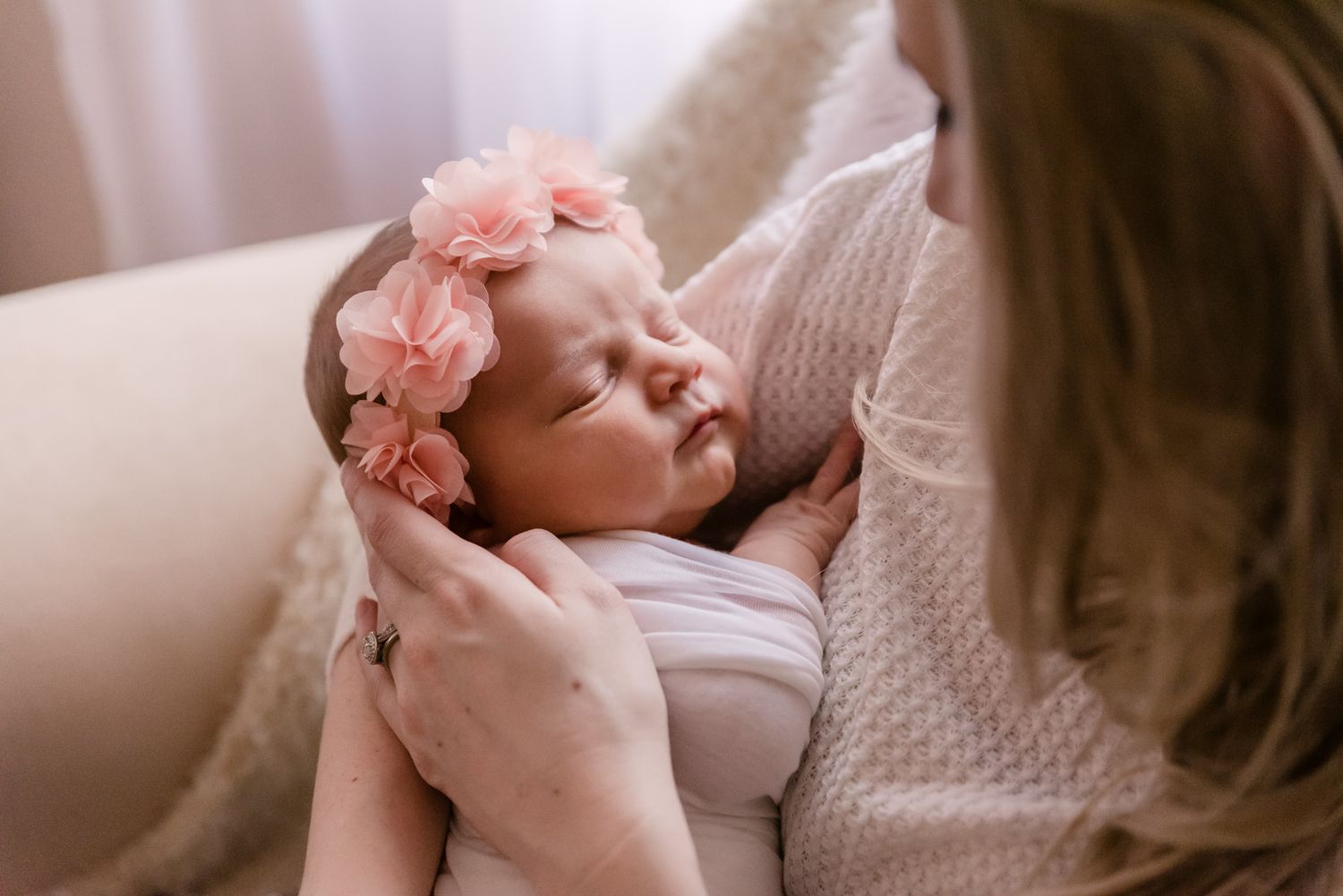 Baby wearing pink bow accessory during intimate family moment.