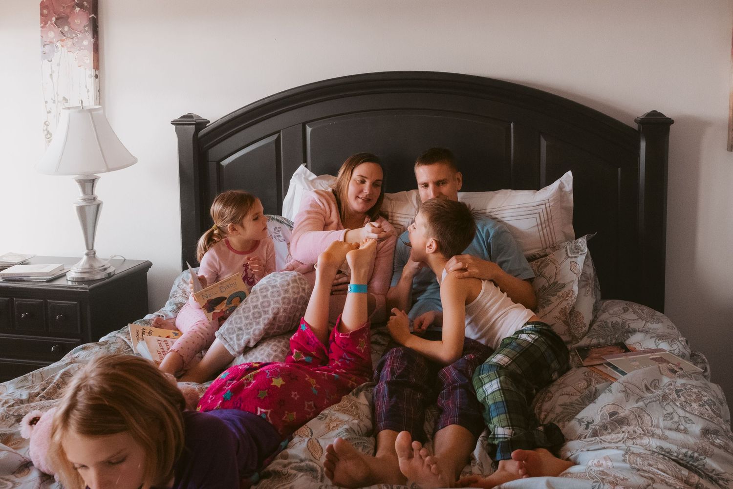 A group lounges comfortably on a bed during a casual gathering.