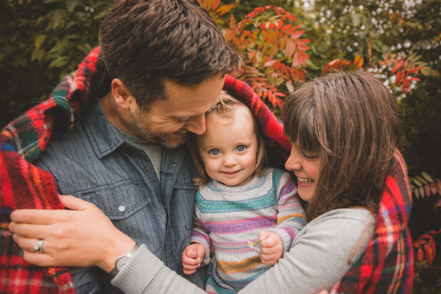 A family shares joyful moments together outdoors during autumn.