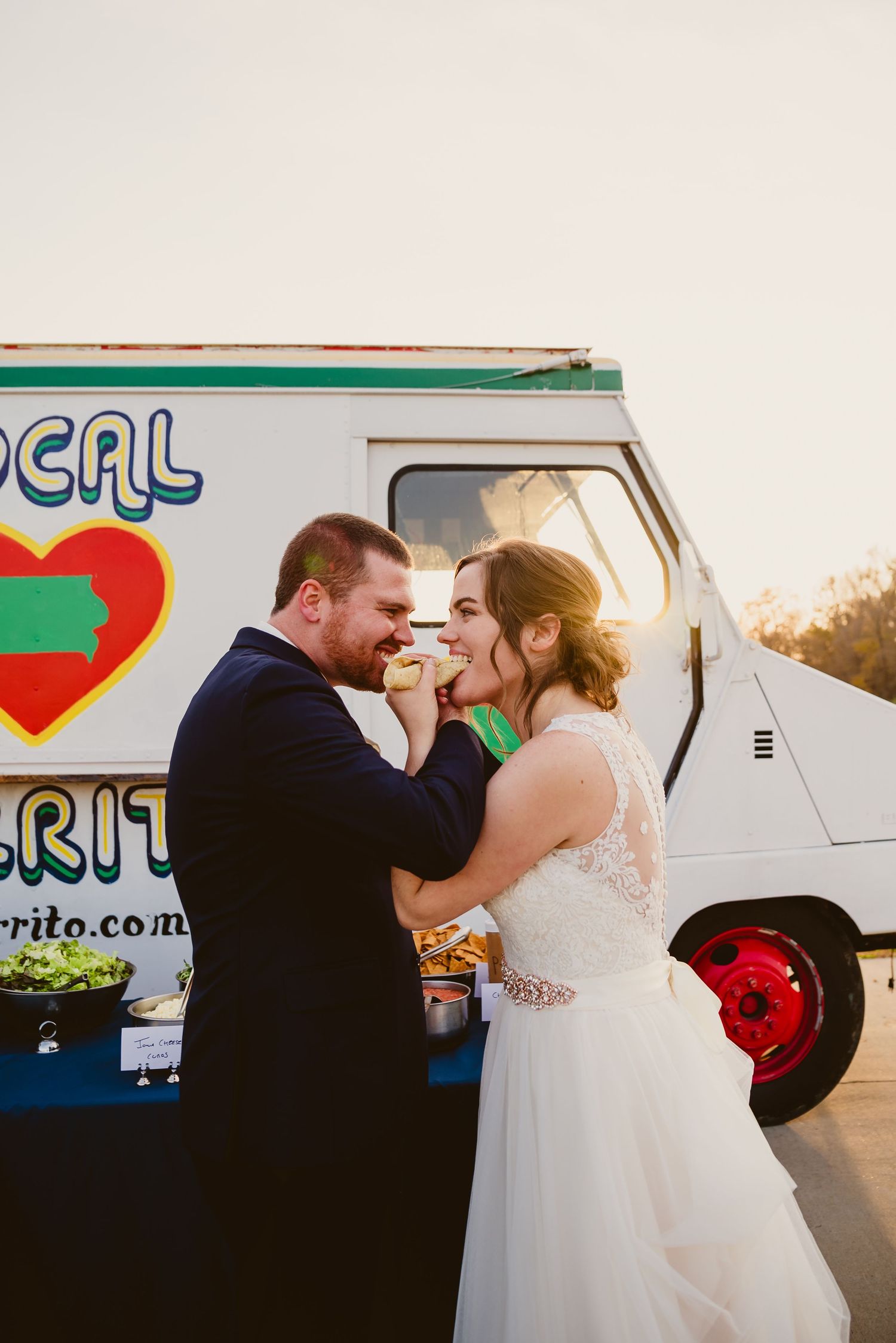 Romantic sunset photos of newlyweds sharing intimate moments near a food truck.