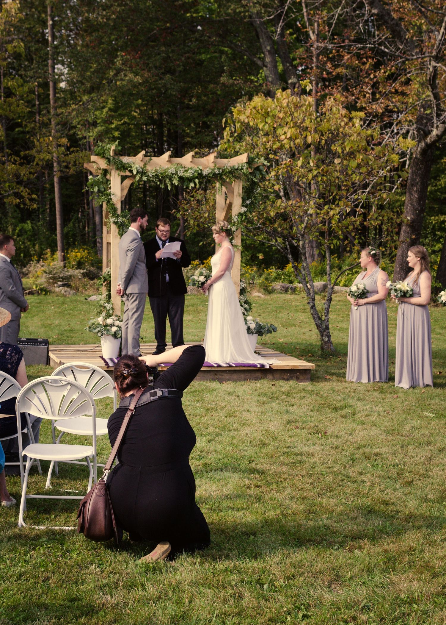 Wedding photographers at work capturing moments during an outdoor ceremony.