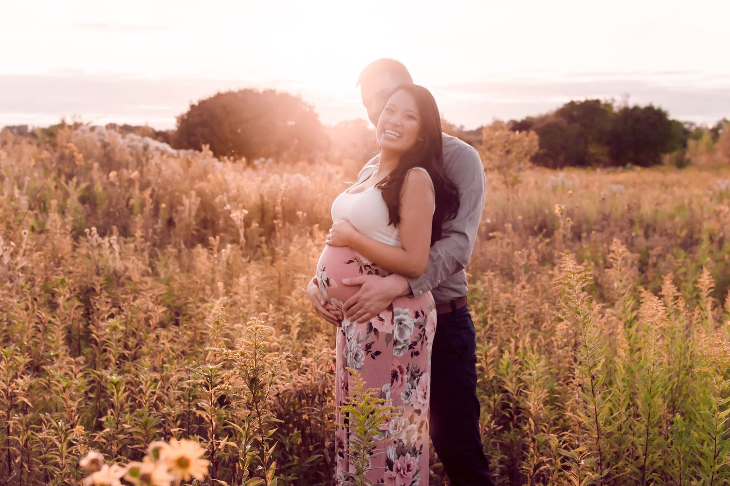 Romantic sunset photoshoot in a golden field with soft natural lighting.