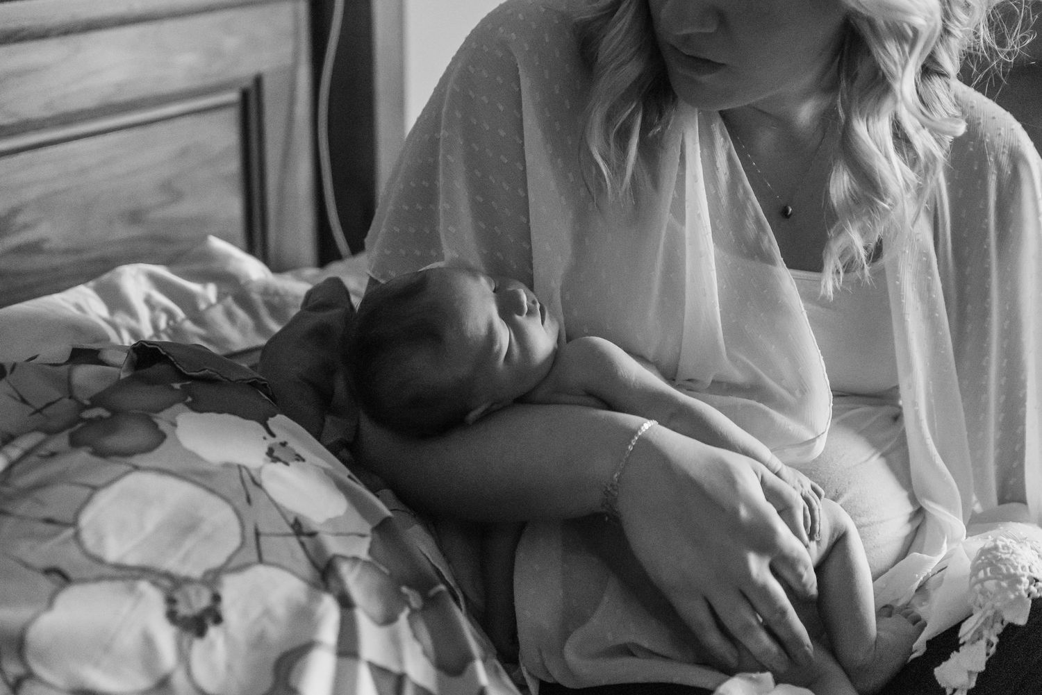 Intimate black and white newborn photography session showing tender moments with baby.