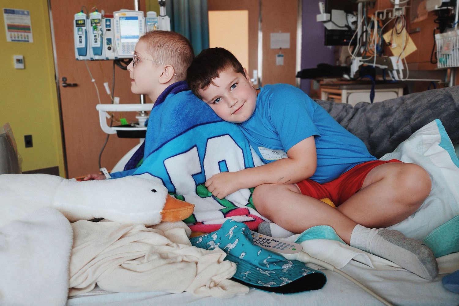 Young patient resting in hospital bed with medical equipment.
