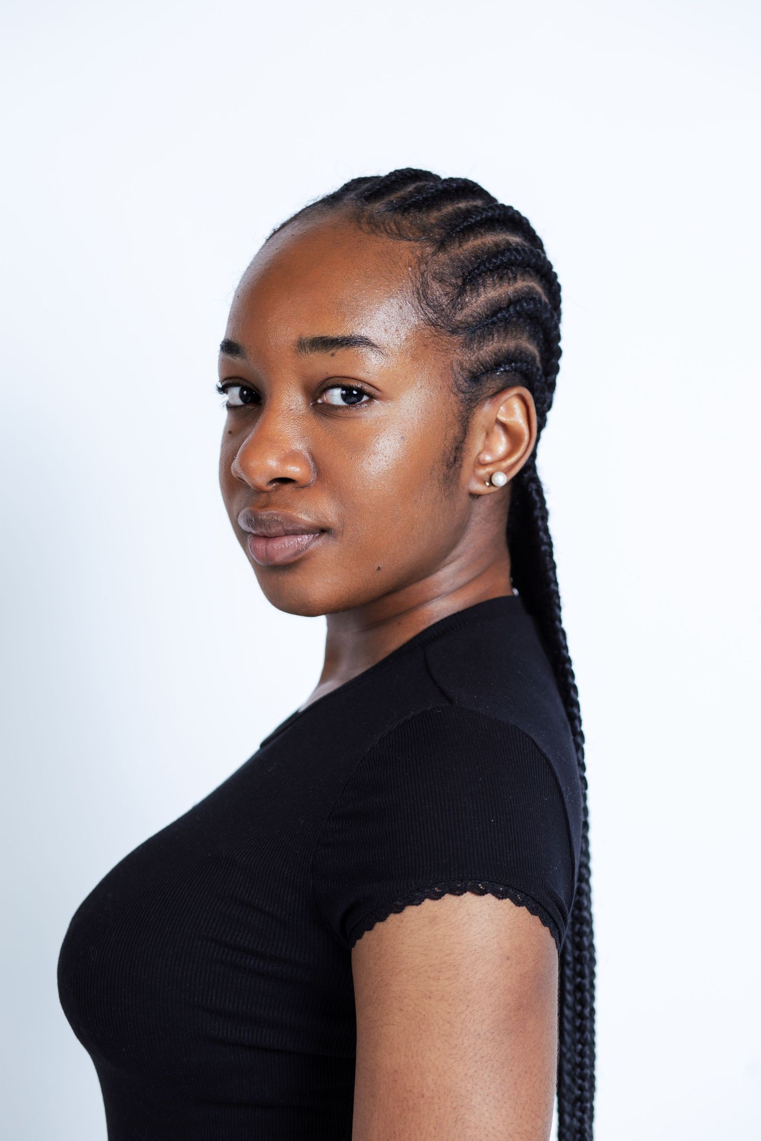 black lady with cornrow photoshoot in front of a white background in a studio in winnipeg for a model portrait session.