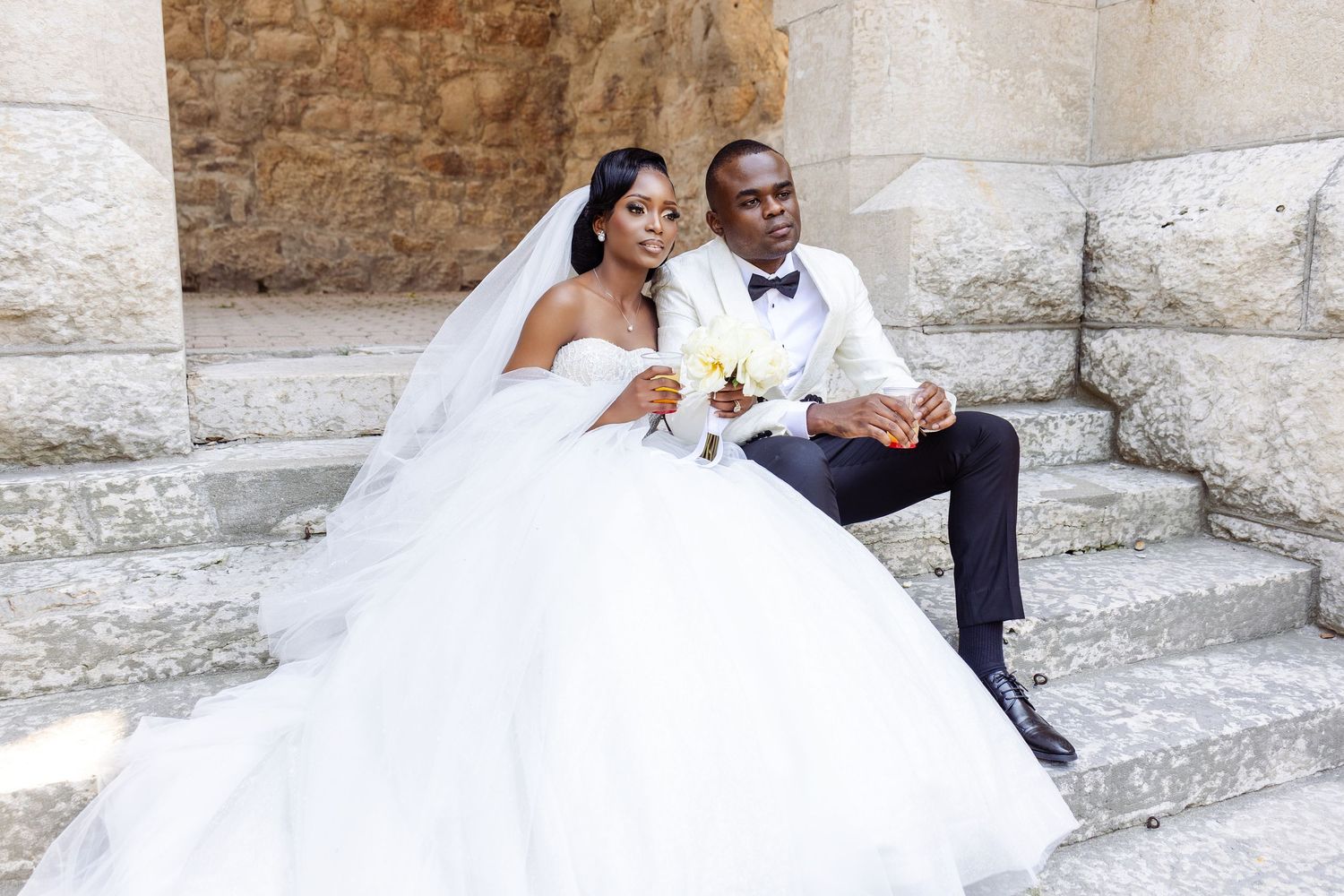 couple posing for their white wedding photoshoot outside in Winnipeg with bridal wear and suit and tie.