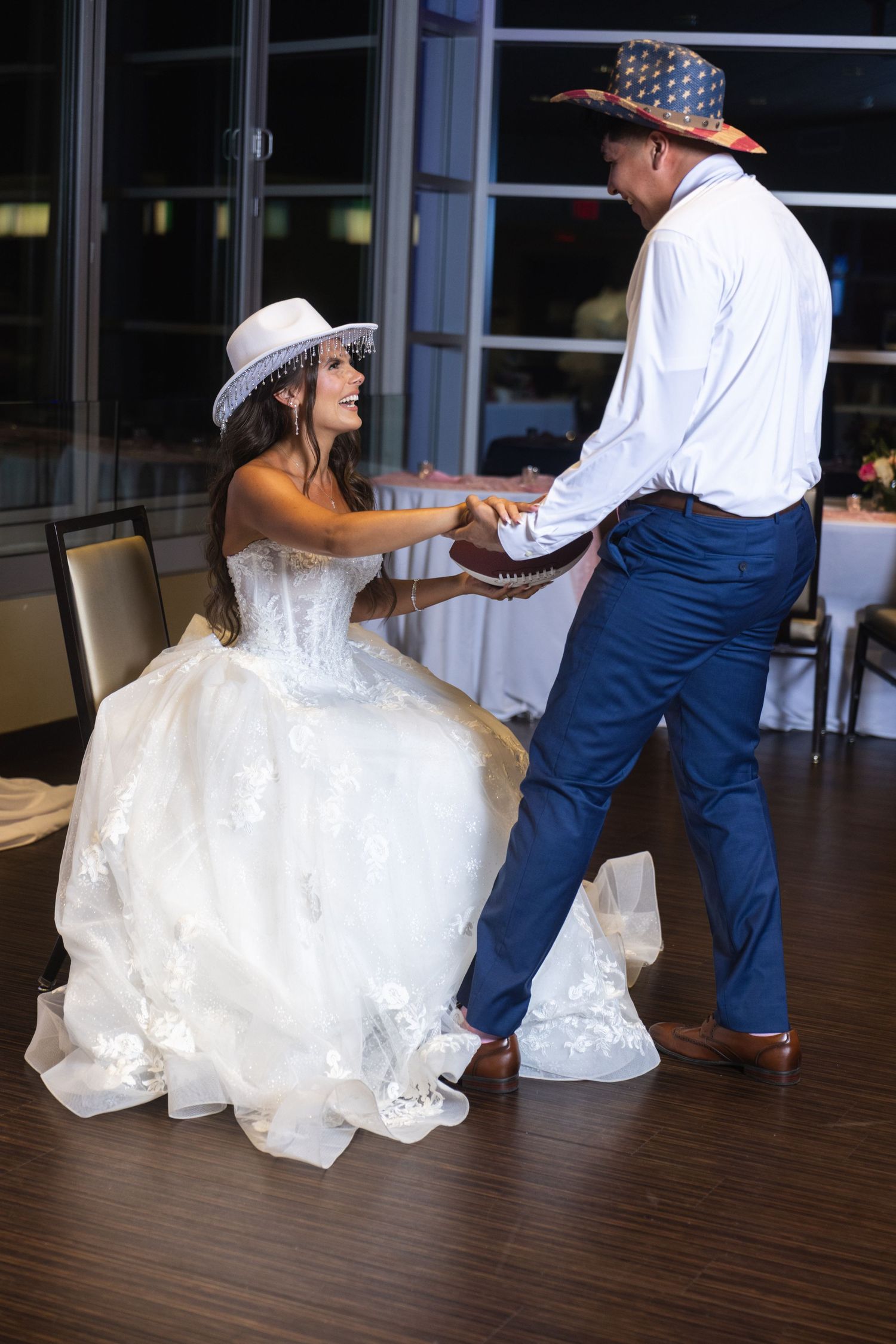 Bride and groom dance together wearing fun cowboy hats during their wedding reception.