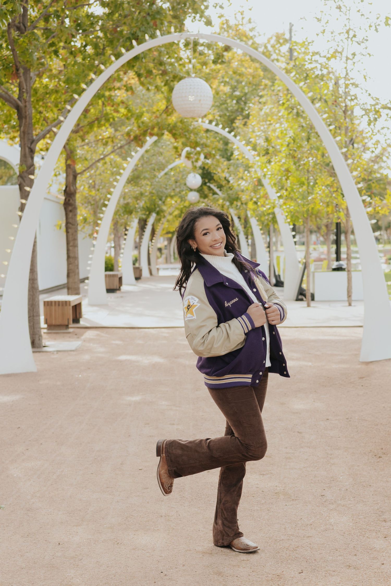 A sequence of five photos showing a person in a varsity jacket and brown pants doing a backflip in a tree-lined path.