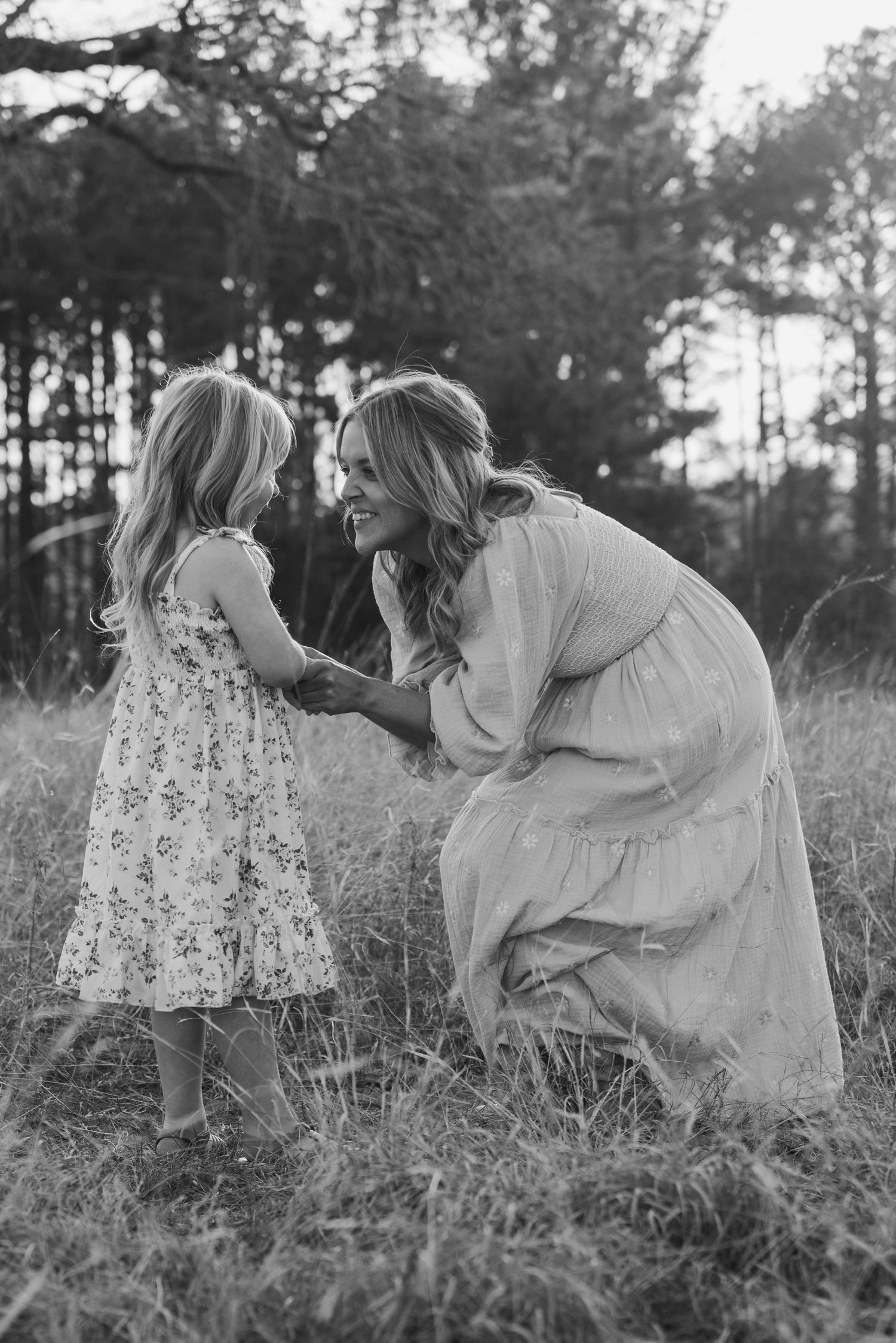 A romantic black and white photo sequence shows a couple in white outfits dancing together in a grassy meadow at dusk.