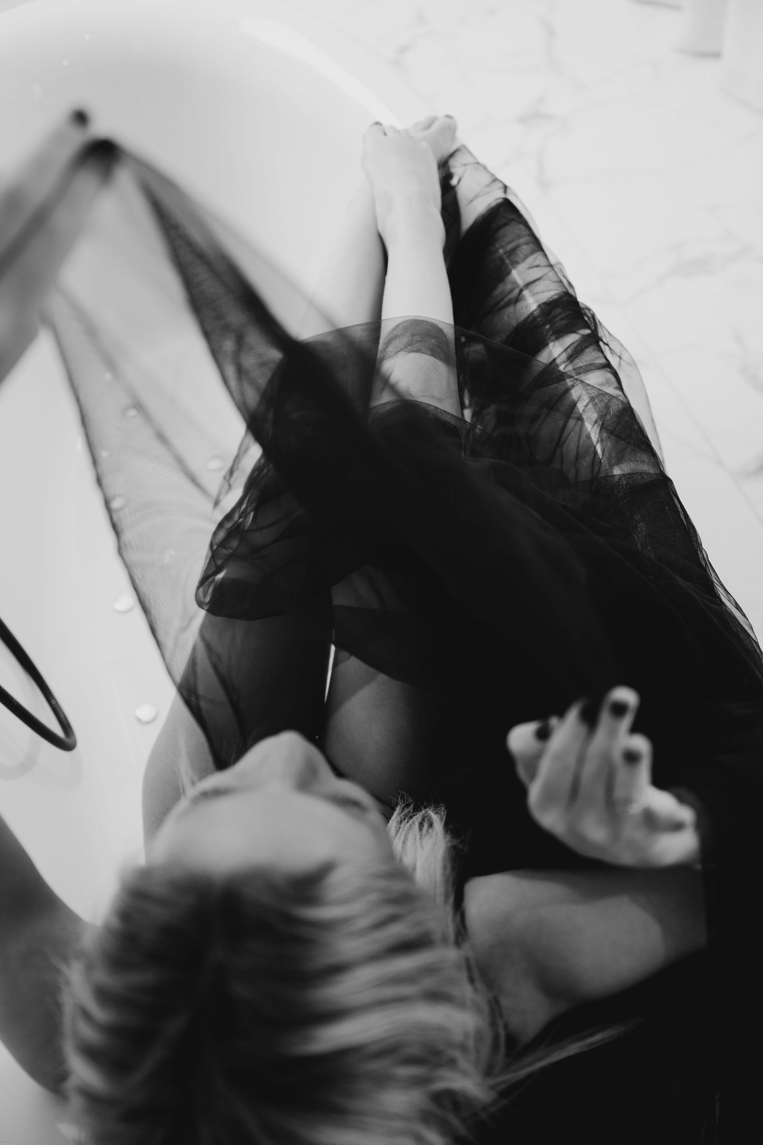 Abstract black and white photographs showing movement with flowing dark fabric creating ethereal shapes.