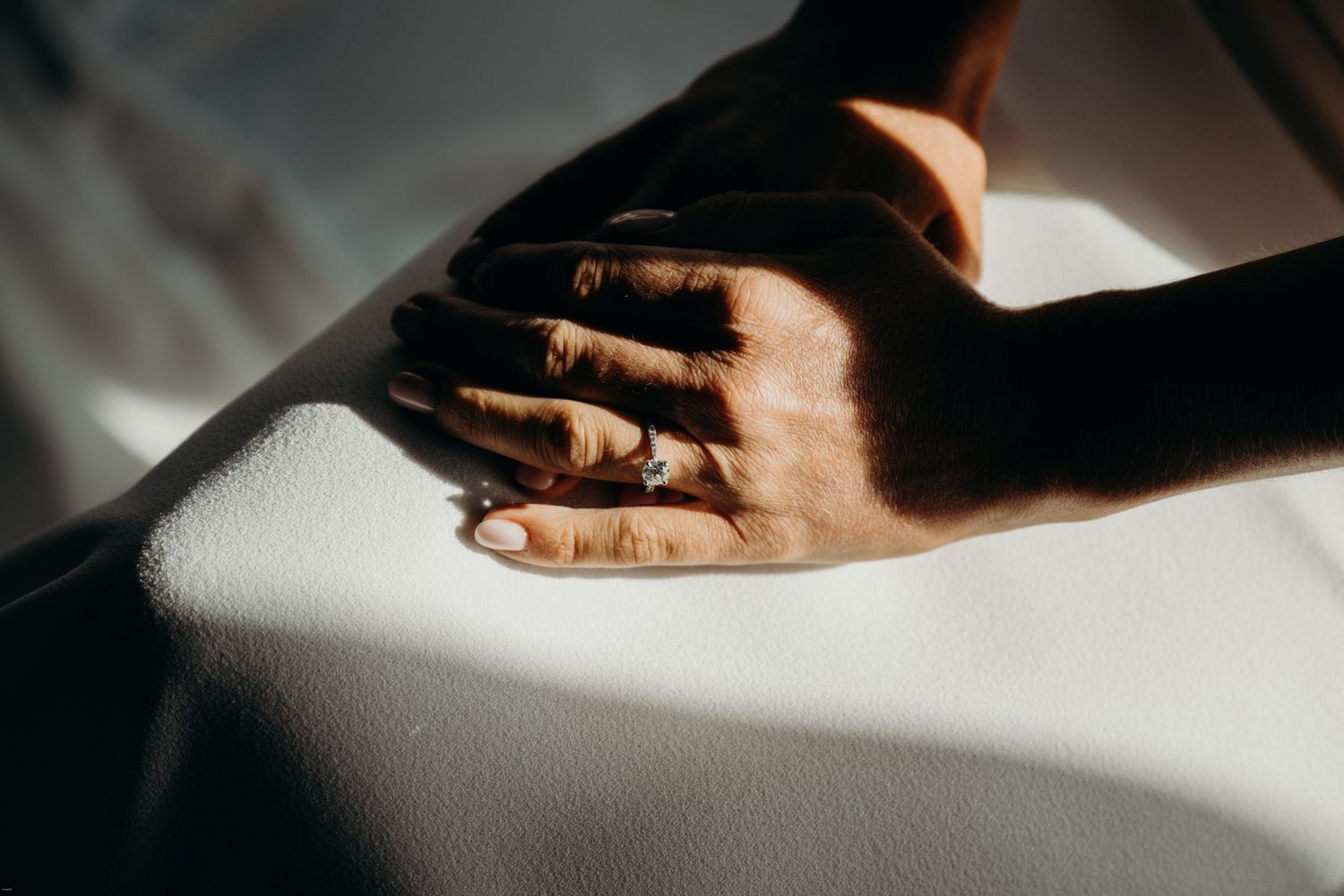 Dramatic close-up of hands with light and shadow creating an artistic composition.
