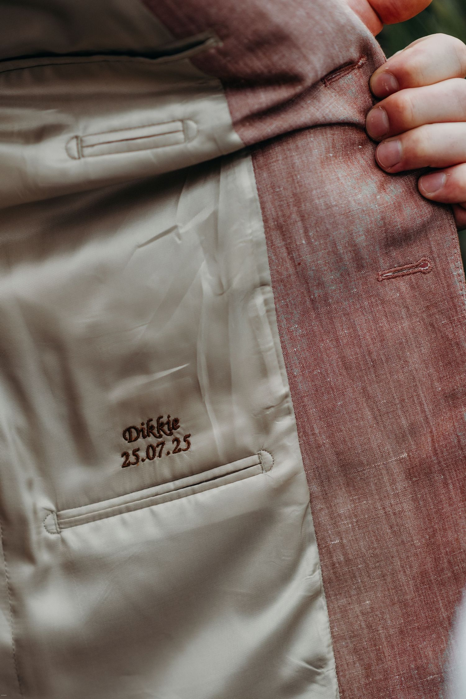 Close-up of suit pocket with embroidered wedding date 23.07.23.