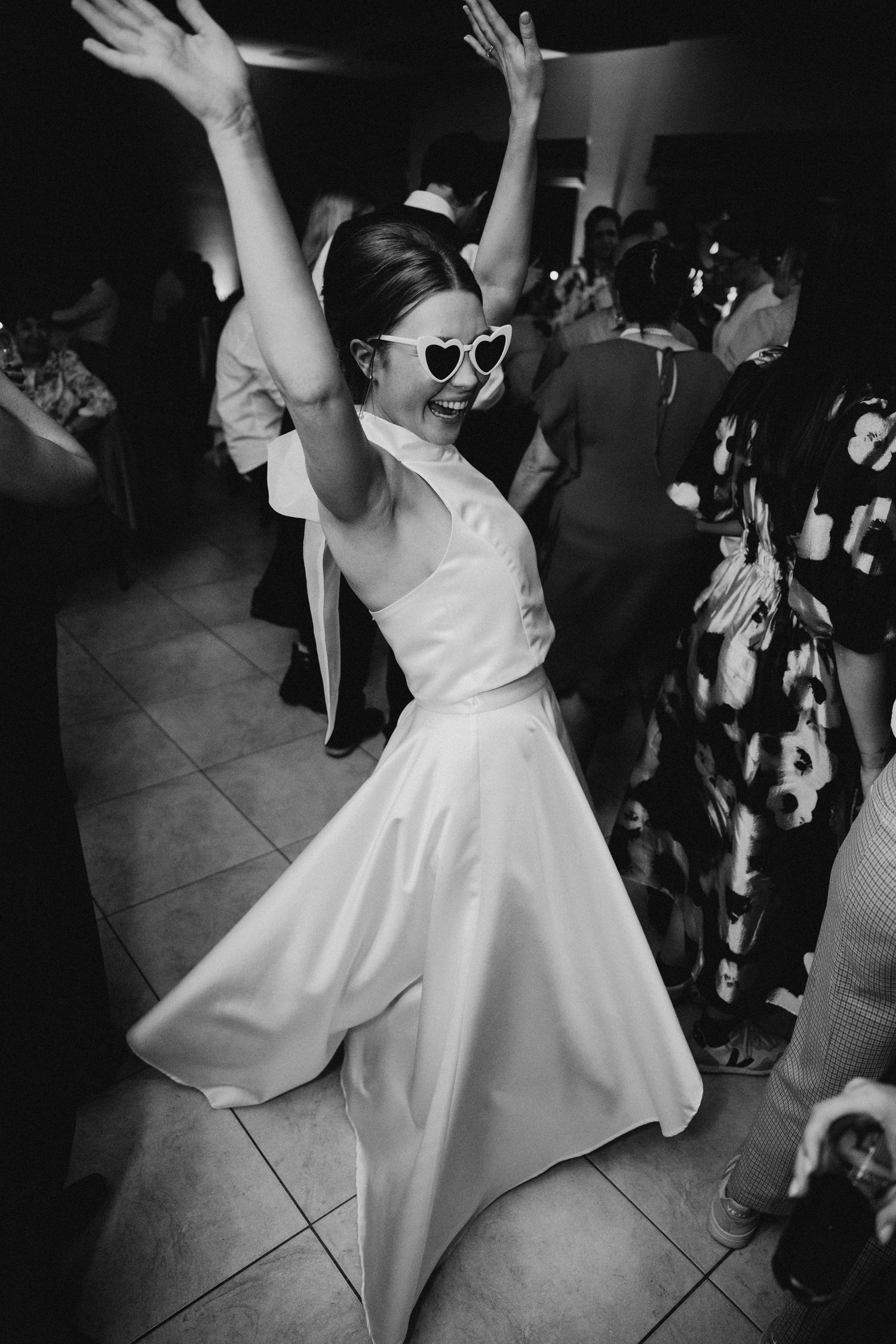 Wedding reception dance party with bride in flowing white dress.