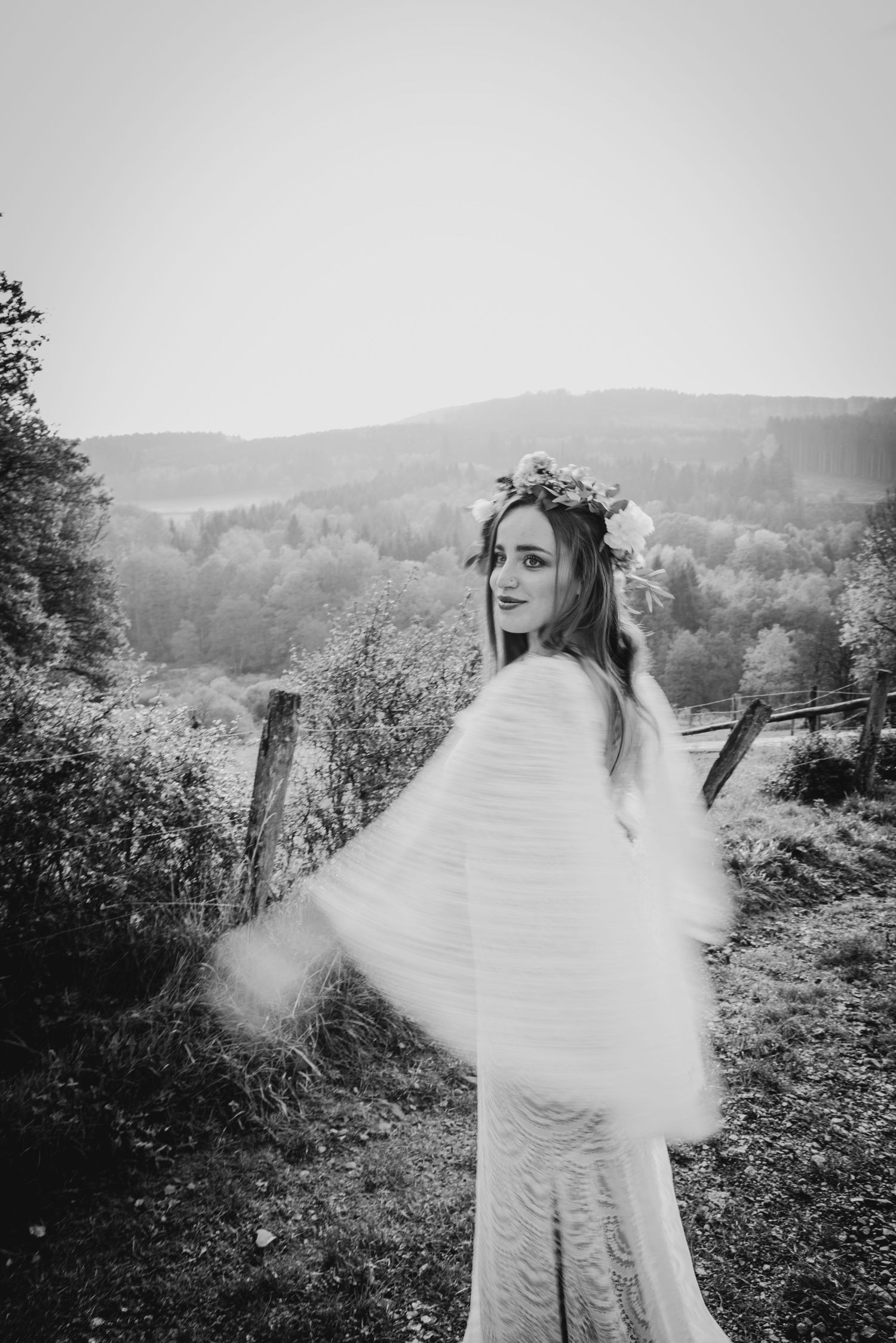 Artistic black and white photos show a bride twirling in her dress against a mountain landscape.