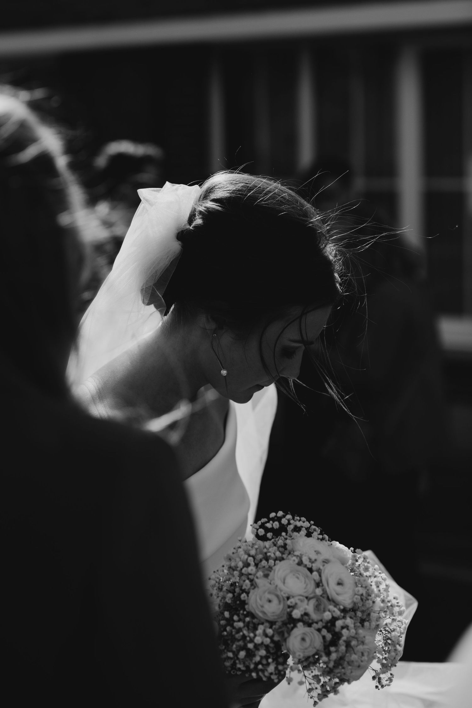 Artistic black and white portrait of a bride with delicate floral details.