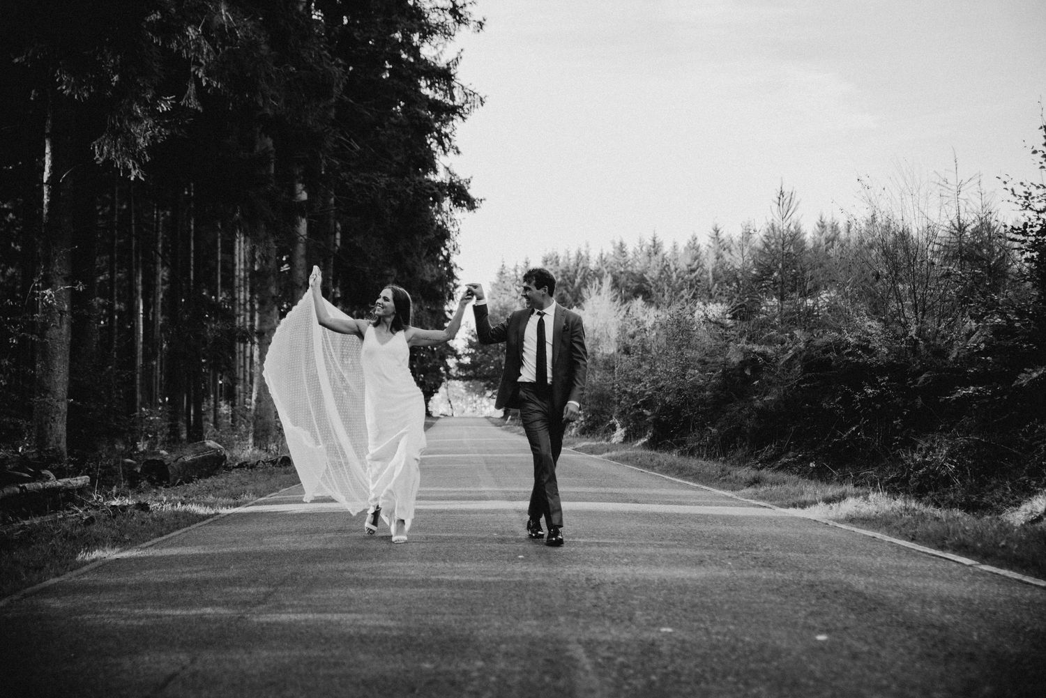 A series of black and white wedding photos showing a couple walking through a scenic outdoor path.
