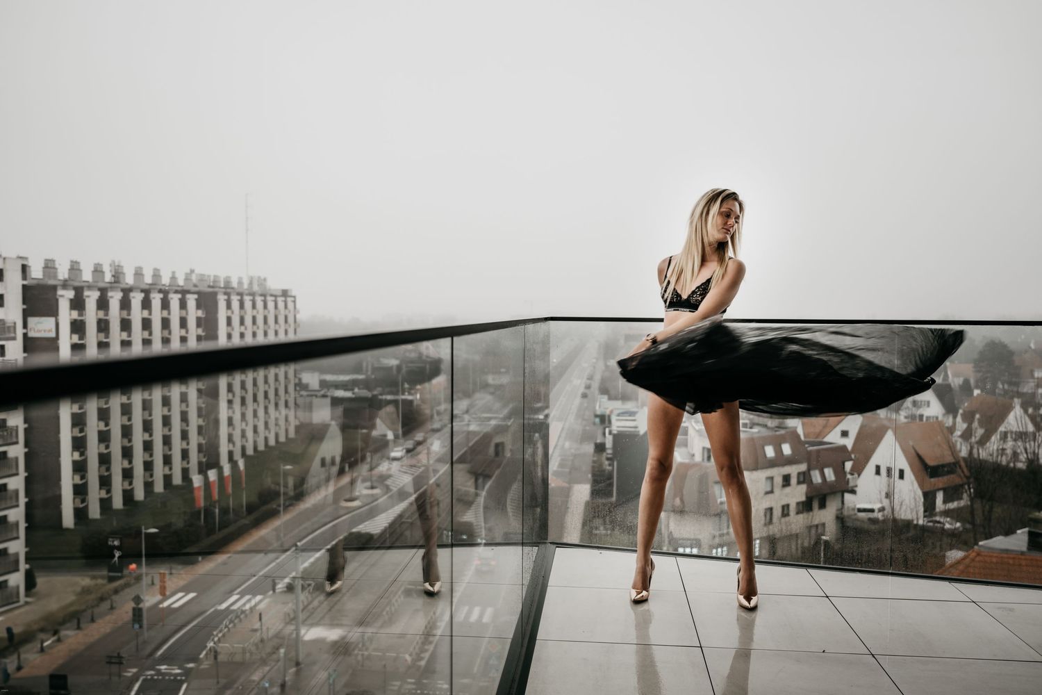 A series of urban rooftop photos showing someone posing in different outfits against a cityscape backdrop.