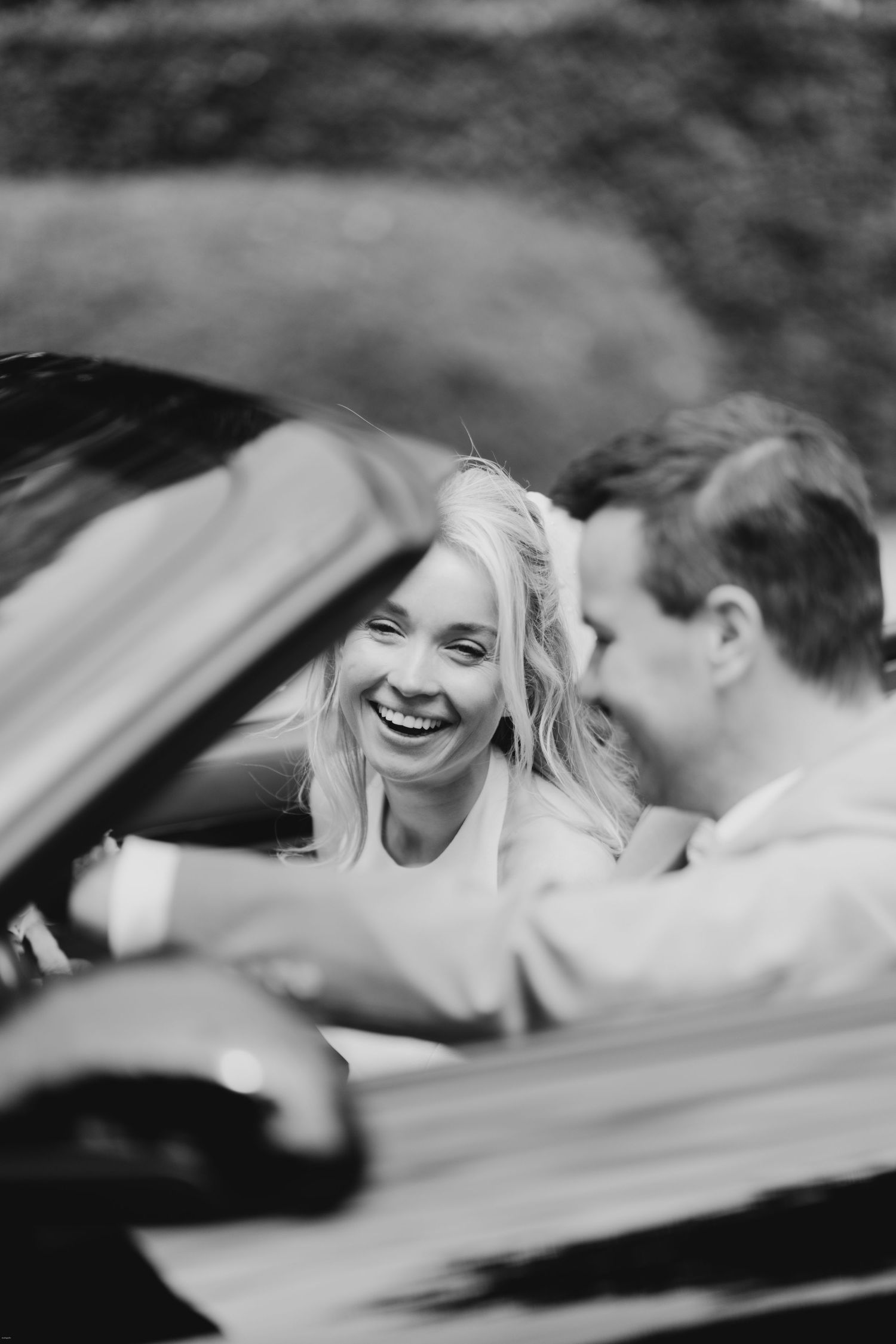 Candid black and white photos capturing joyful laughter through a car window.