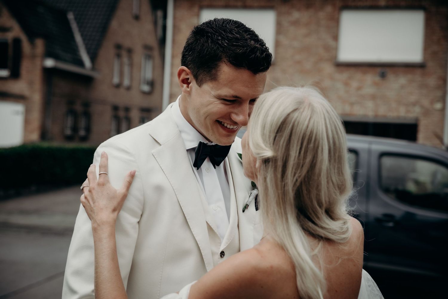 Romantic moment captured against brick building exterior.