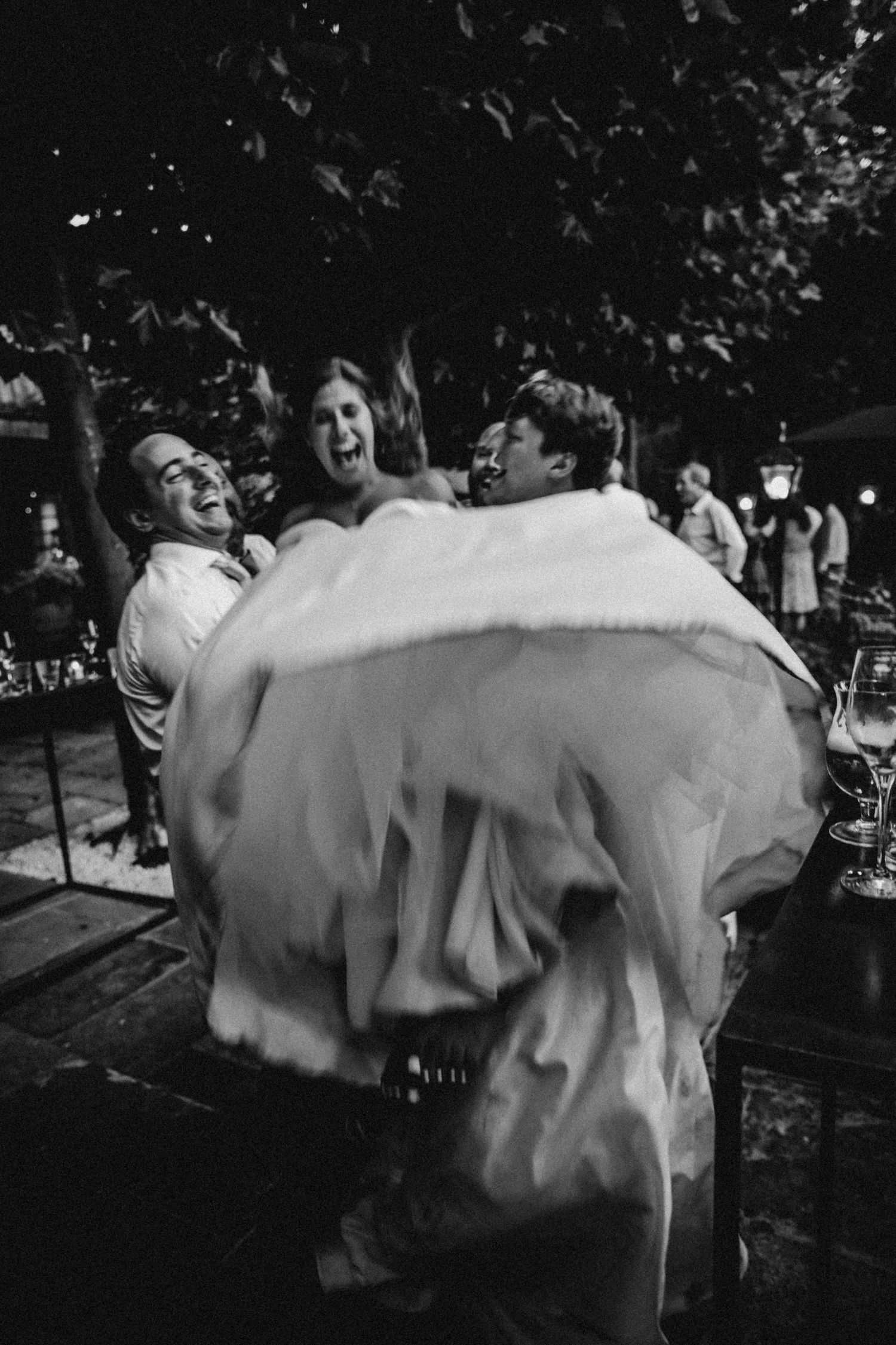 Joyful celebration moment with flowing white dress fabric in black and white.