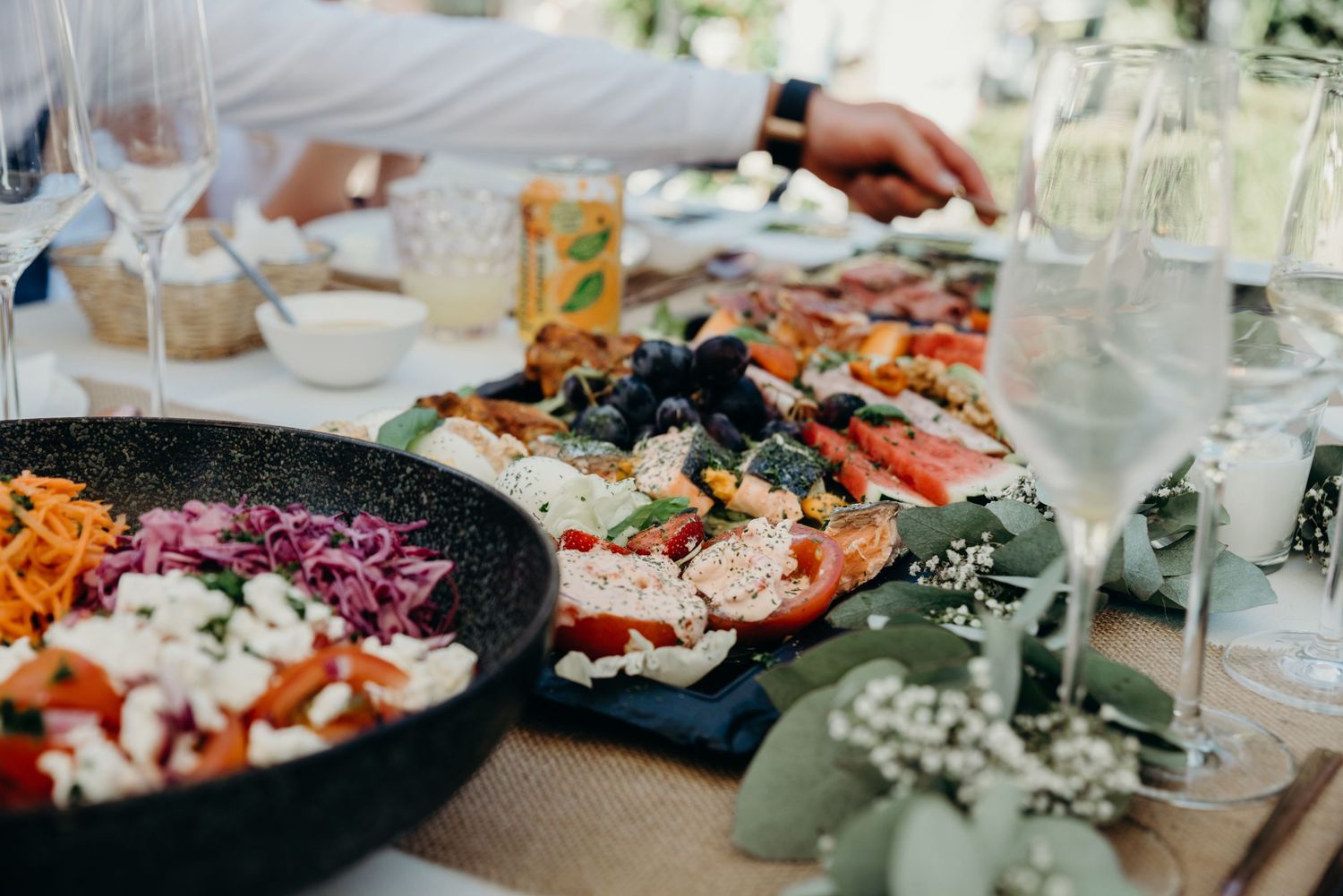 Elegant wedding reception table settings with colorful dishes and floral arrangements.