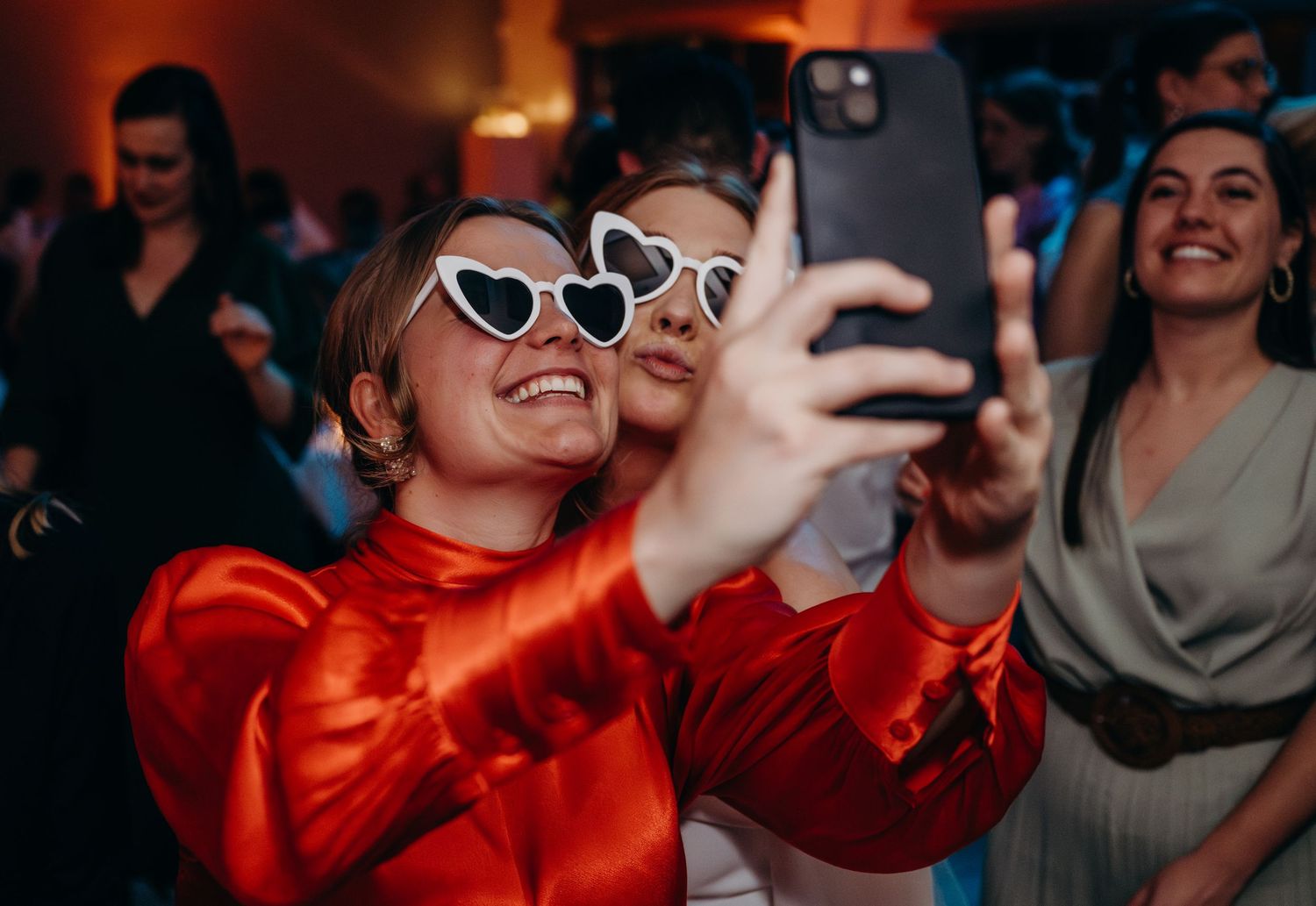 Wedding reception guests dancing and celebrating in vibrant red attire.