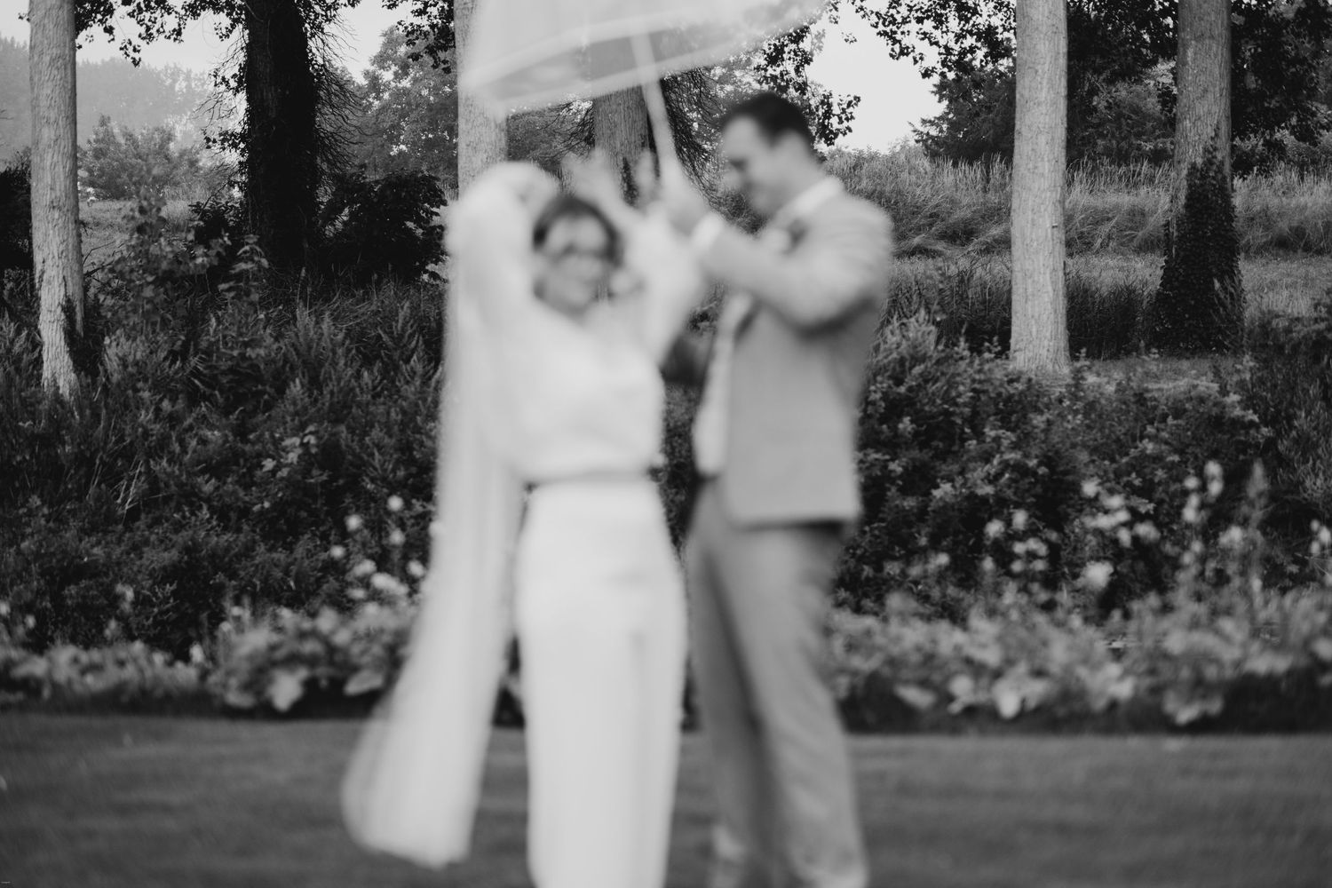 Wedding party walking together through a lush garden setting.