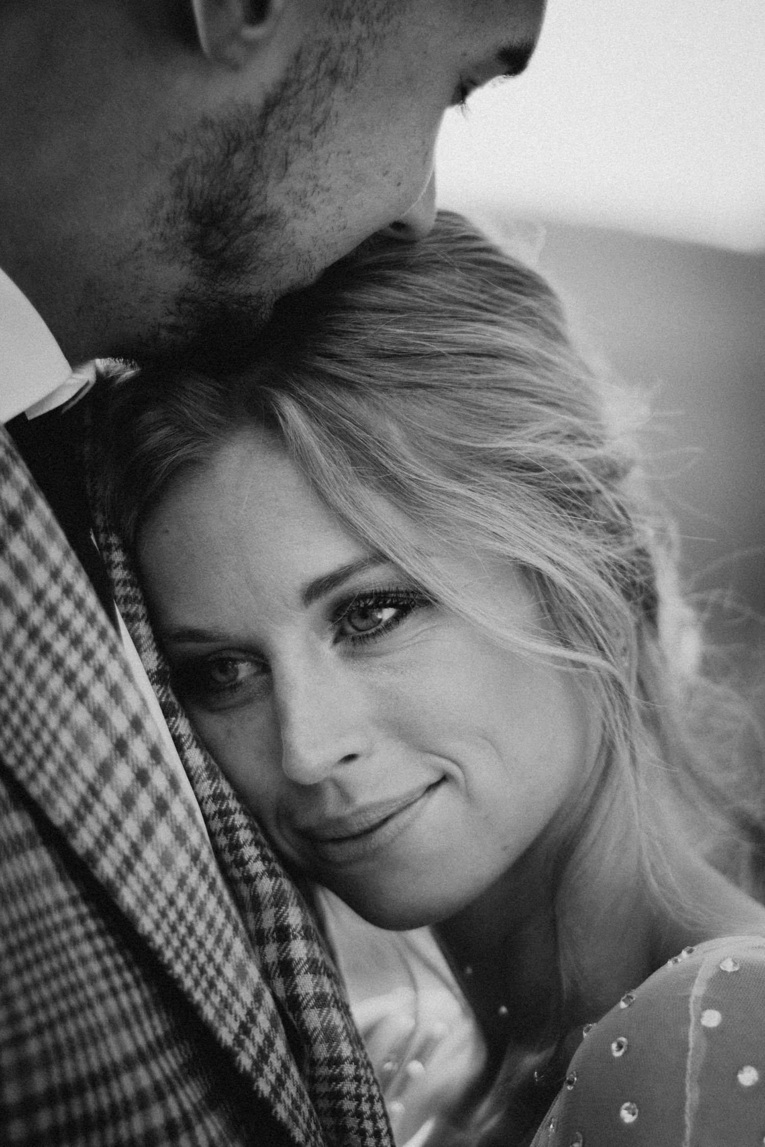 Black and white close-up portrait showing intimate moment between couple.