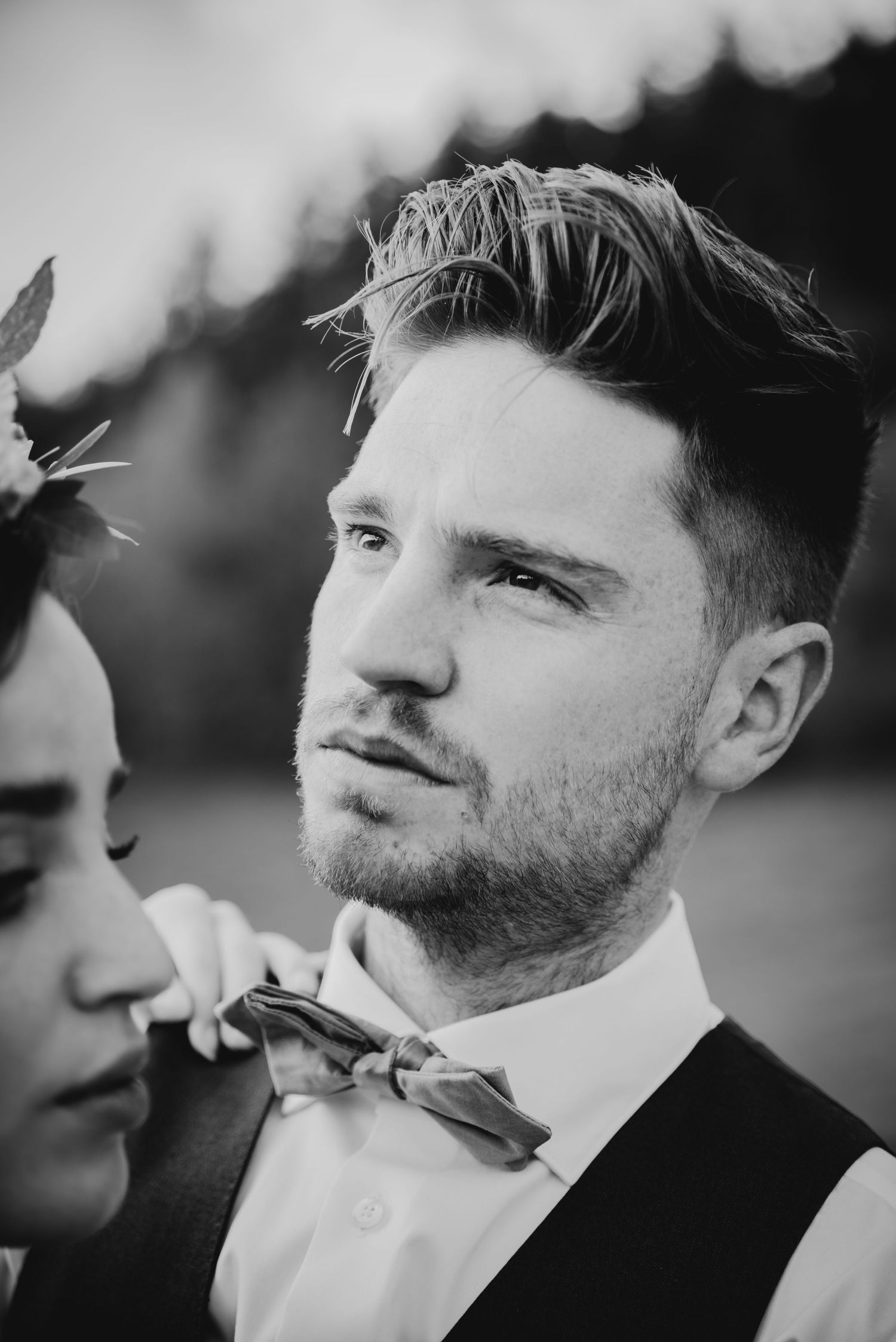 Close-up black and white portrait of groom wearing bowtie.