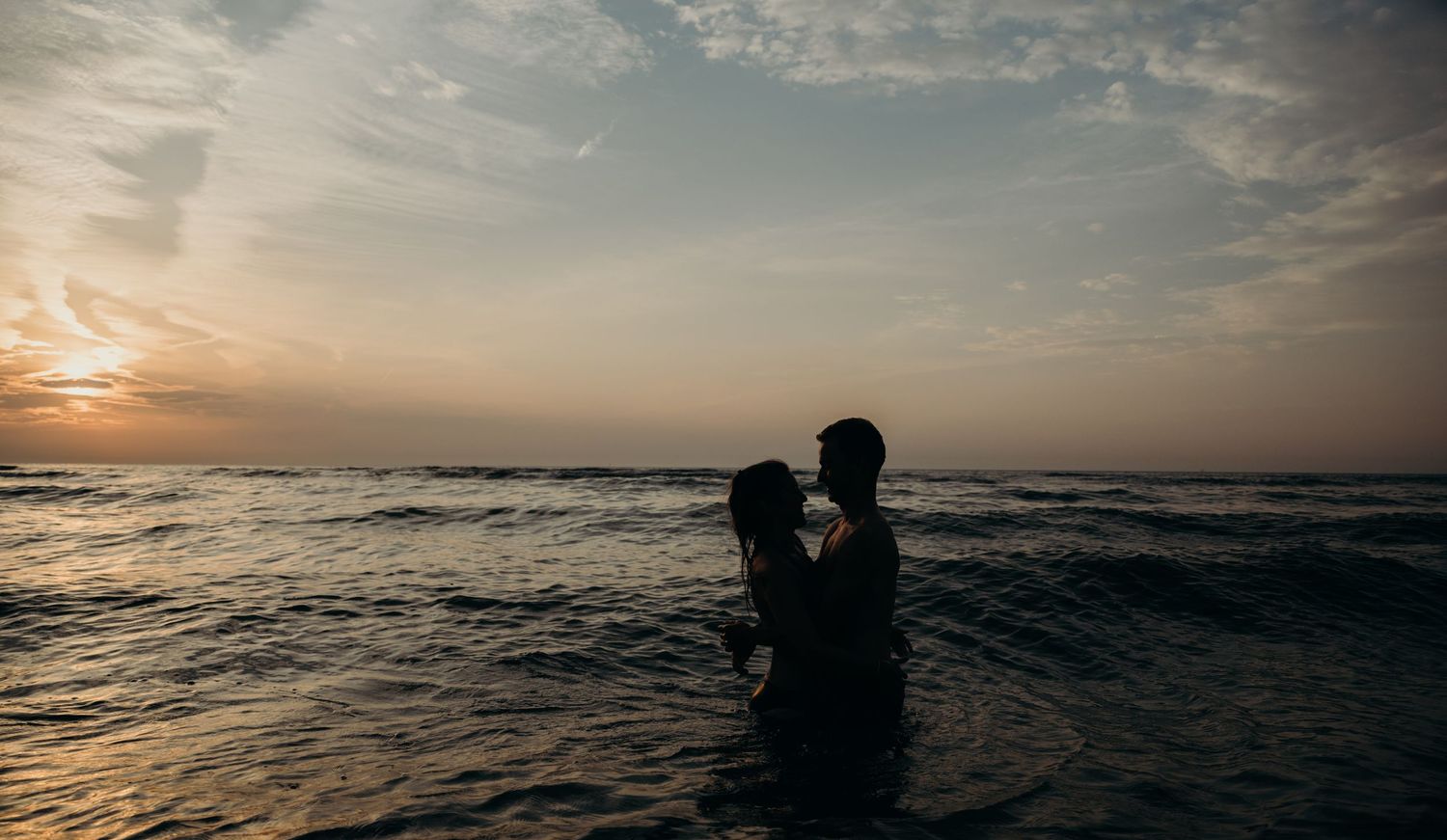 Lifestyle fotoshoot van een koppel in de zee tijdens goldenhour een silhouette foto