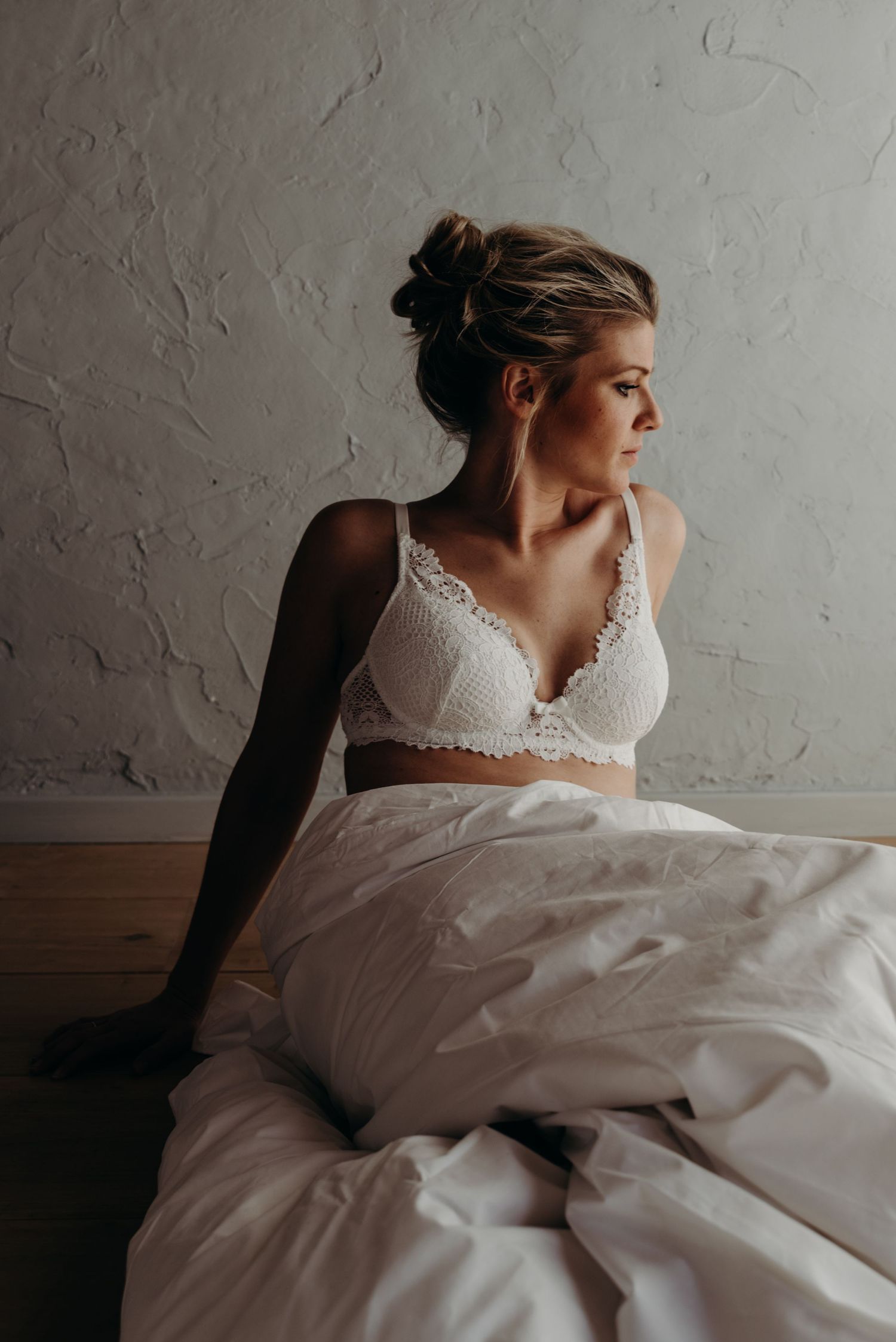A series of intimate bridal portraits in white showing delicate lace details against a textured wall background.