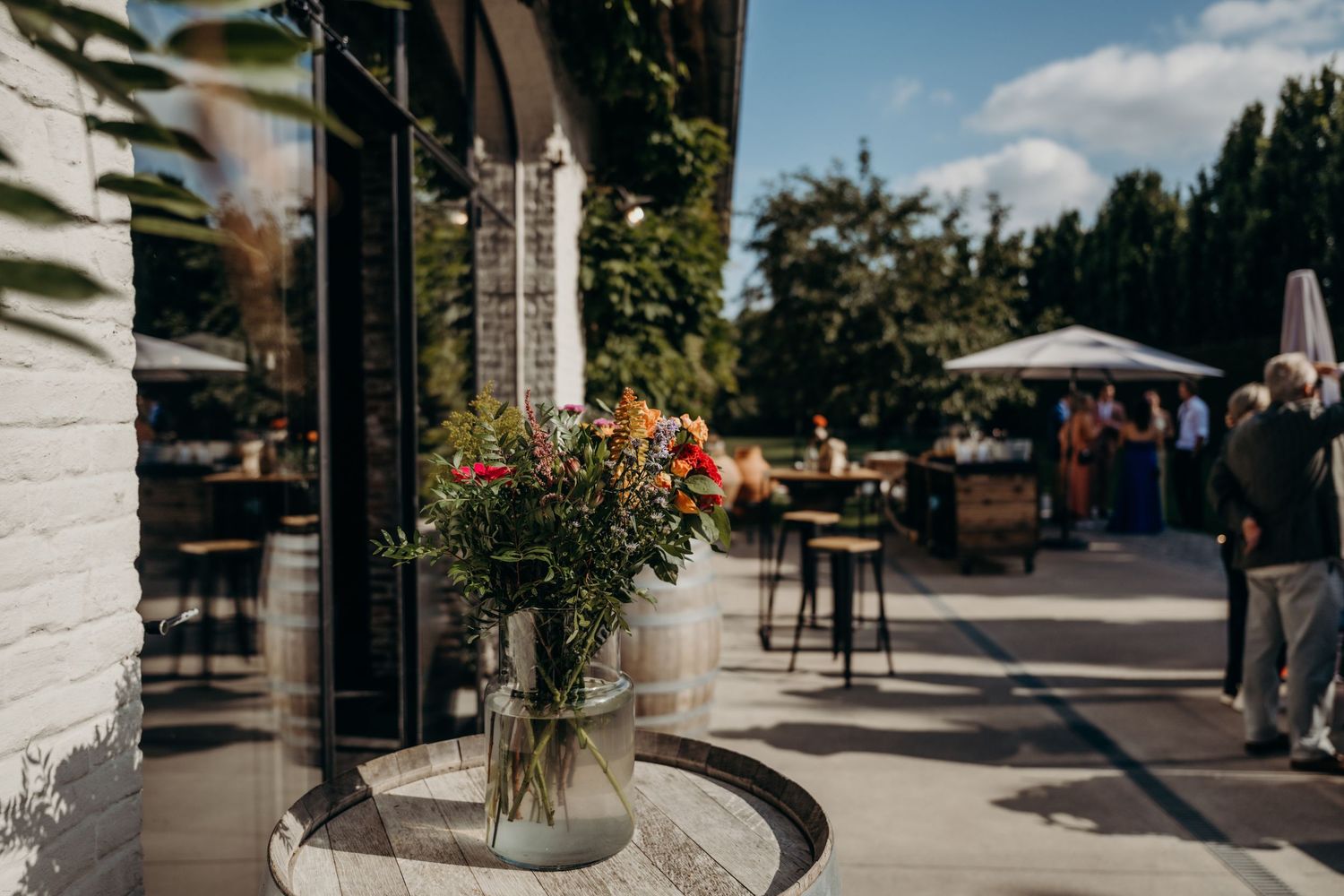 Modern outdoor venue space with stone columns and landscaped garden paths.