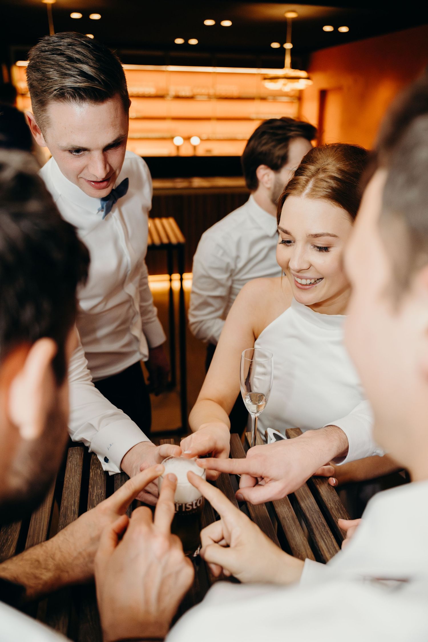 Group of friends playing a fun party game at a wedding reception.