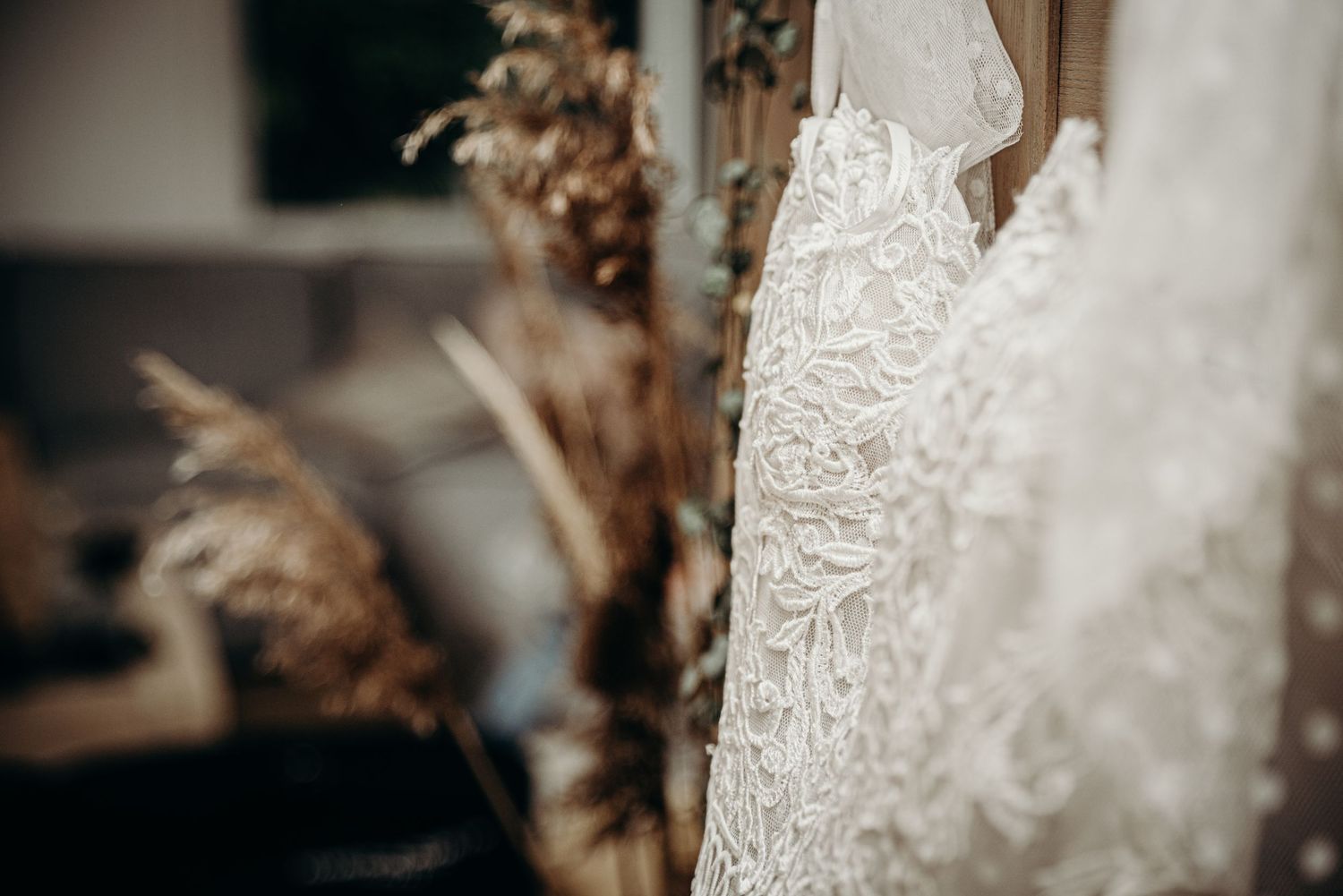 Close-up of delicate lace and beading details on a white wedding gown.