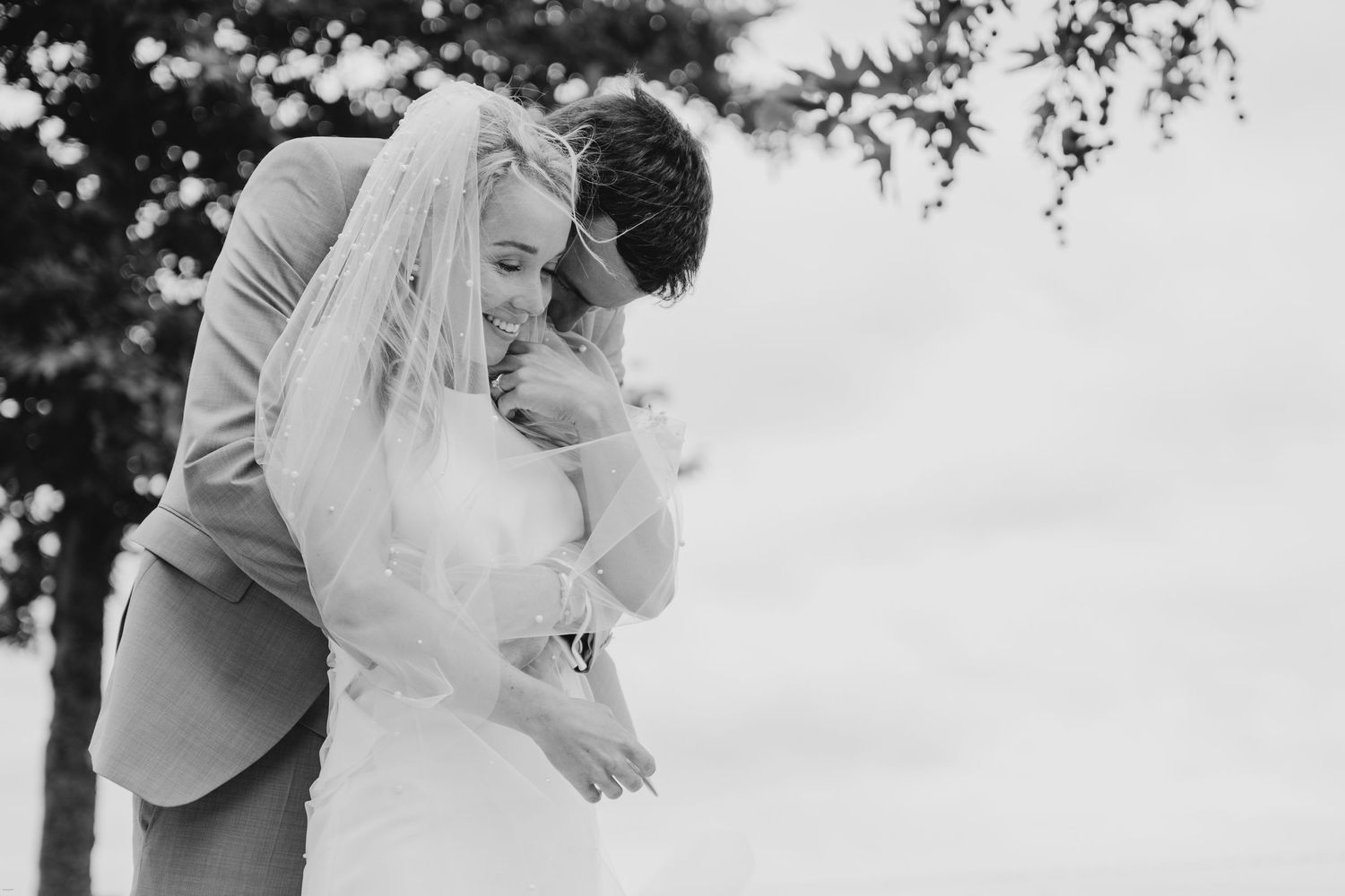 Black and white photo of an intimate outdoor wedding moment.
