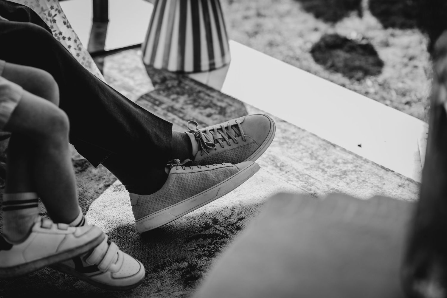 Close-up detail shot of wedding shoes on textured ground.
