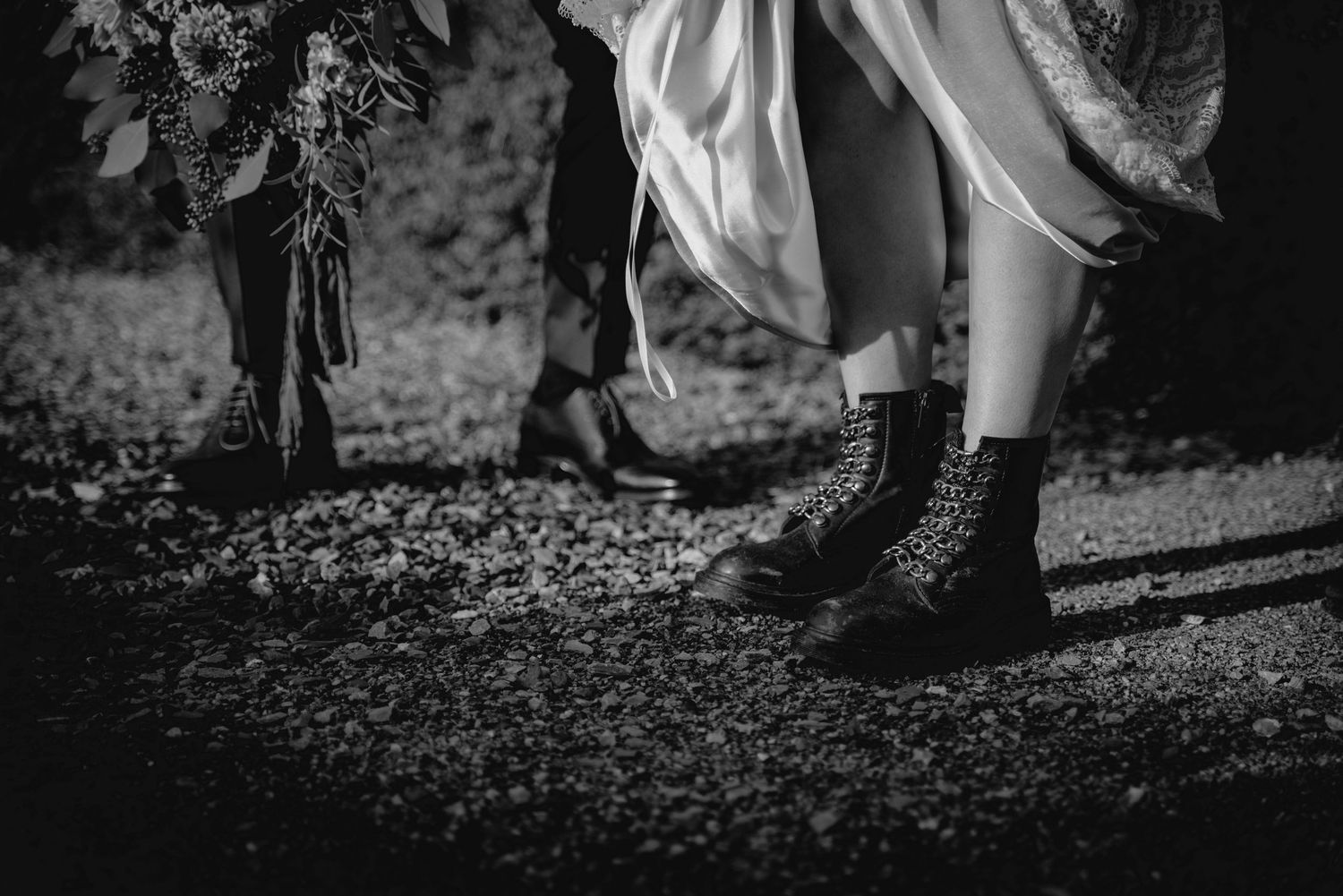 Black and white detail shots capture feet and movement during an outdoor wedding ceremony.