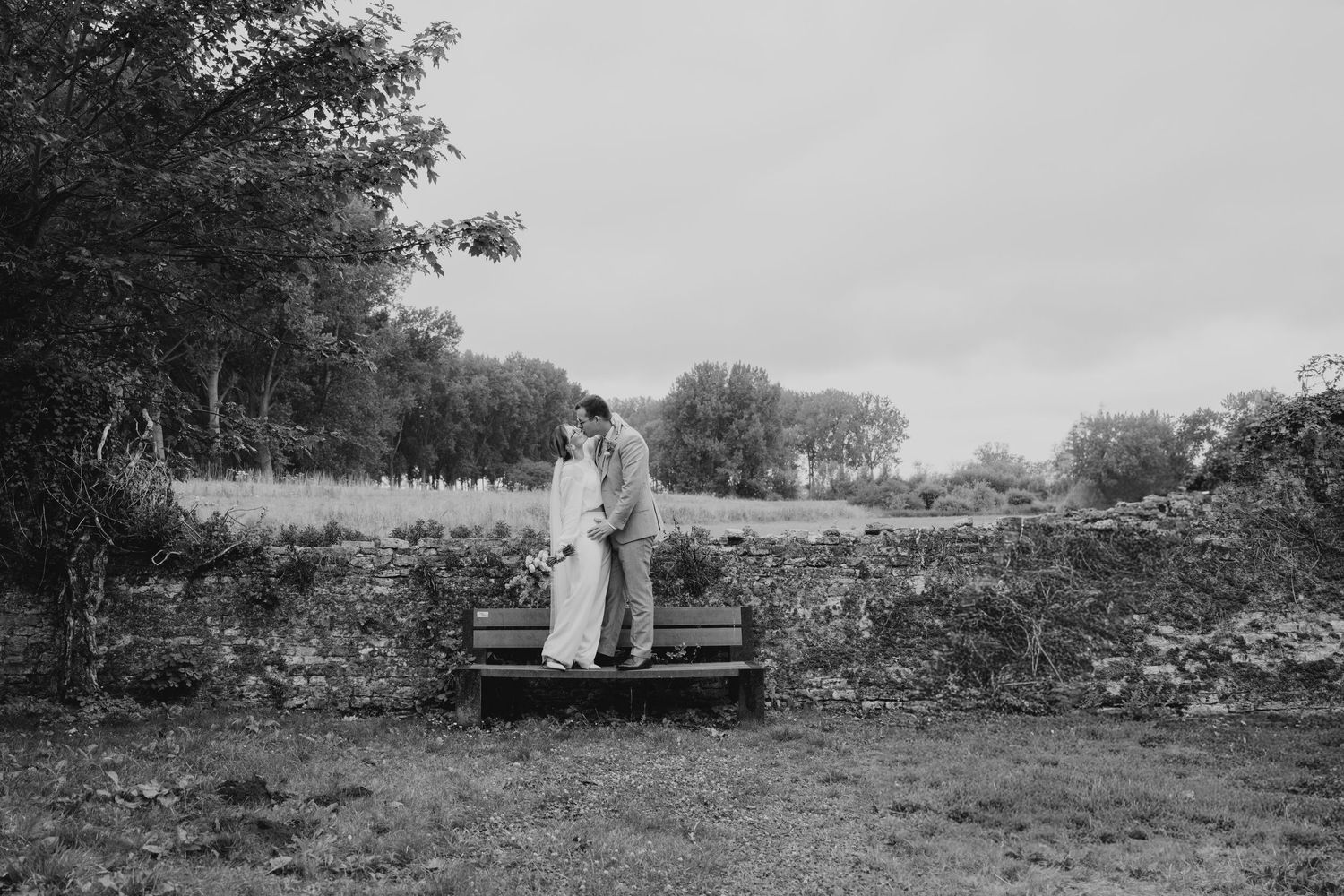 Black and white panoramic landscape showing figures in the distance on a rural hillside.