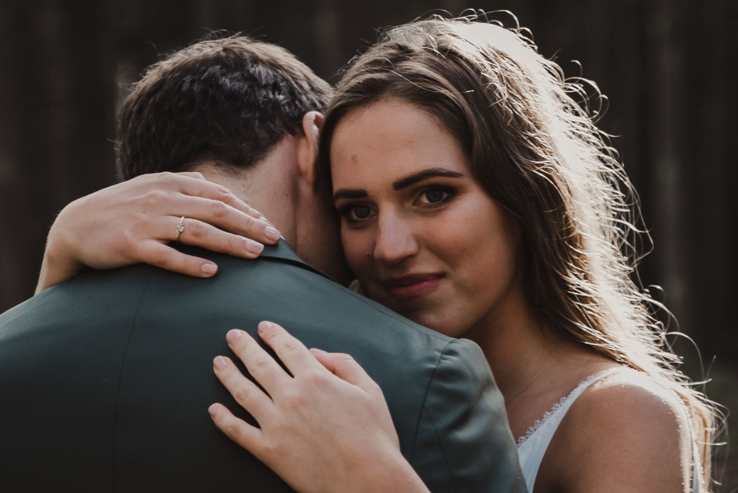 Intimate embrace between couple during outdoor wedding photoshoot.